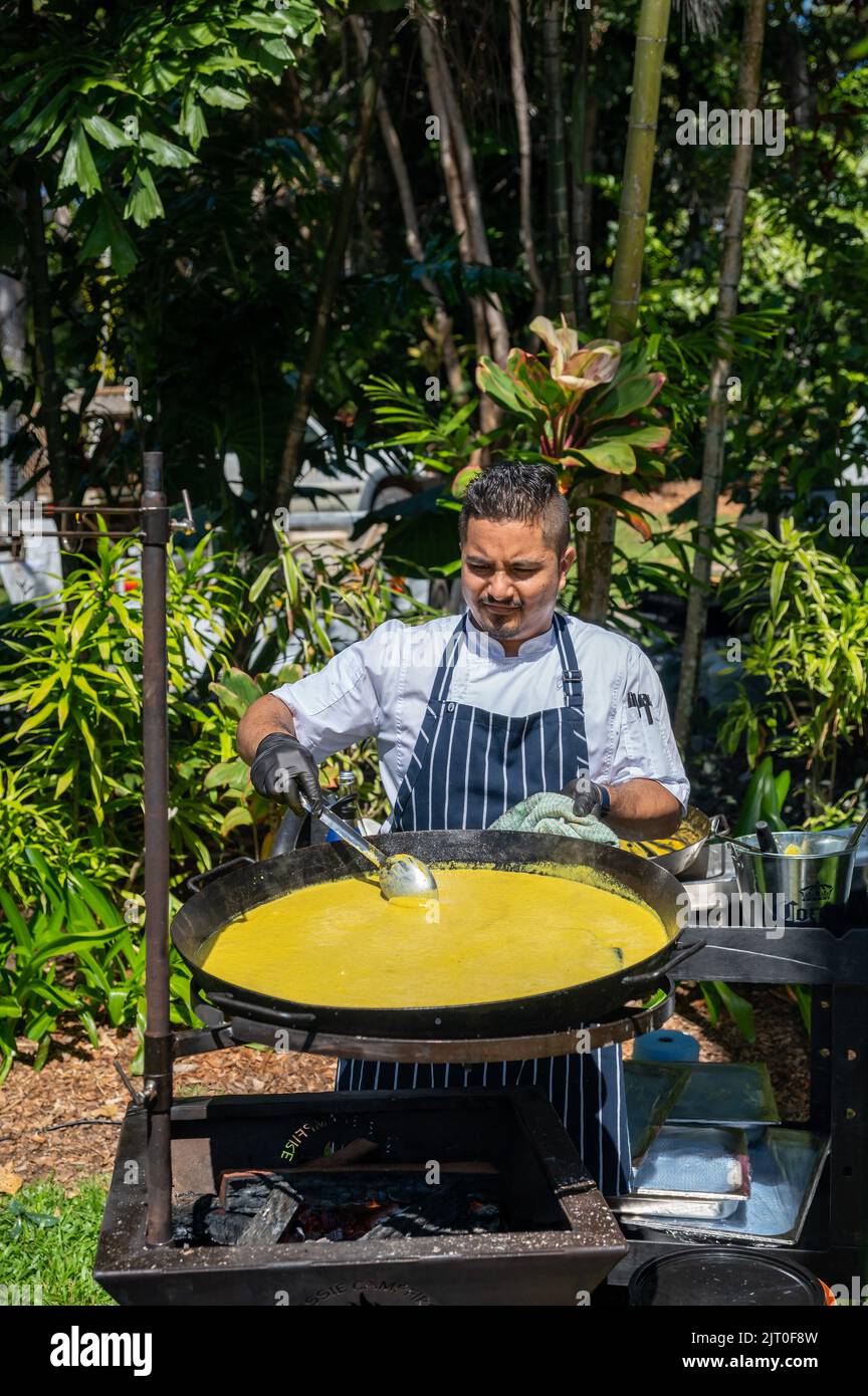 Der Küchenchef vor einem großen Wok kocht stolz Curry-Muscheln im Sheraton Mirage Taste Port Douglas Food and Drink Festival Australia. Stockfoto