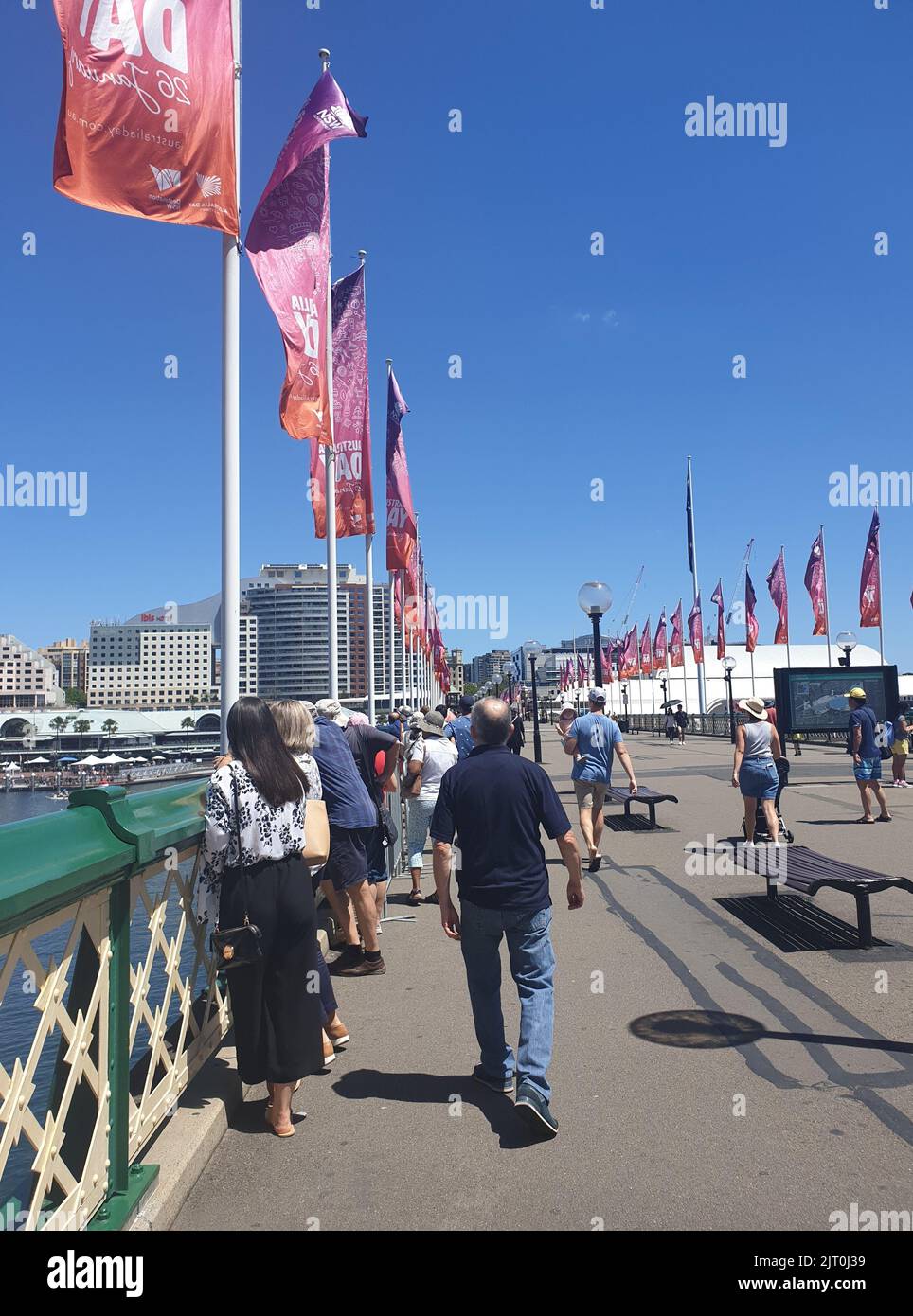 Eine Vertikale von Menschen, die am Darling Harbour in Sydney, Australien, spazieren gehen Stockfoto