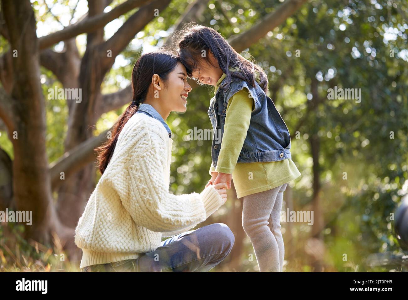 Junge asiatische Mutter und Vorschultochter genießen die Natur mit einer guten Zeit im Park Stockfoto