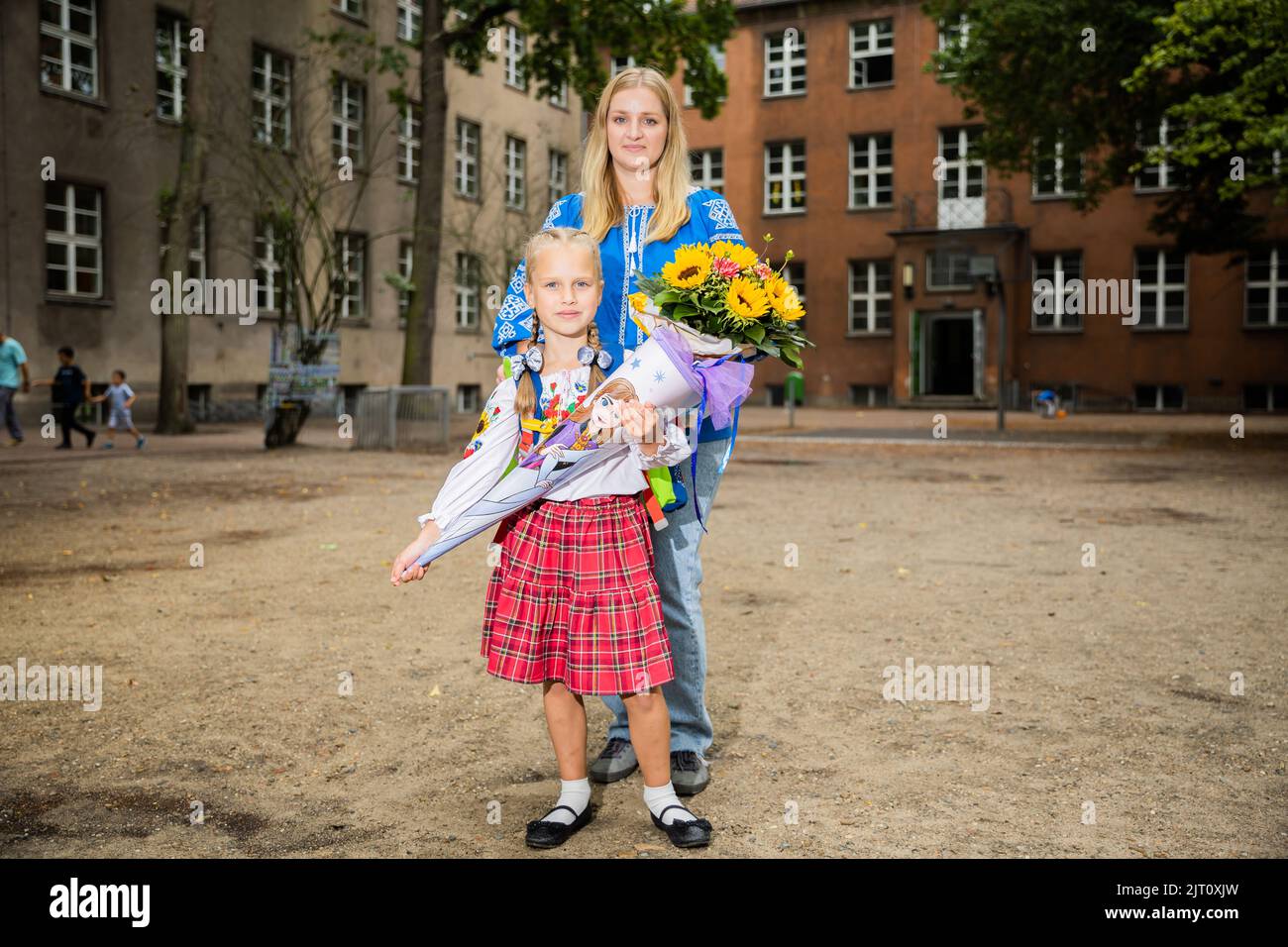 Berlin, Deutschland. 27. August 2022. Die 6-jährige Yeva aus der Ukraine steht mit ihrer Mutter Yuliia nach dem Schulstart im Hof der TempelherrenGrundschule im Berliner Stadtteil Tempelhof. Yeva floh mit ihrer Mutter Yuliia aus der Stadt Schytomyr westlich von Kiew nach Berlin und blieb privat bei einer Familie. Insgesamt drei Kinder aus der Ukraine wurden in die Tempelherrenschule eingeschrieben. Quelle: Christoph Soeder/dpa - ACHTUNG: Nur zur redaktionellen Verwendung im Zusammenhang mit der aktuellen Berichterstattung und nur bei vollständiger Erwähnung der oben genannten Credit/dpa/Alamy Live News Stockfoto