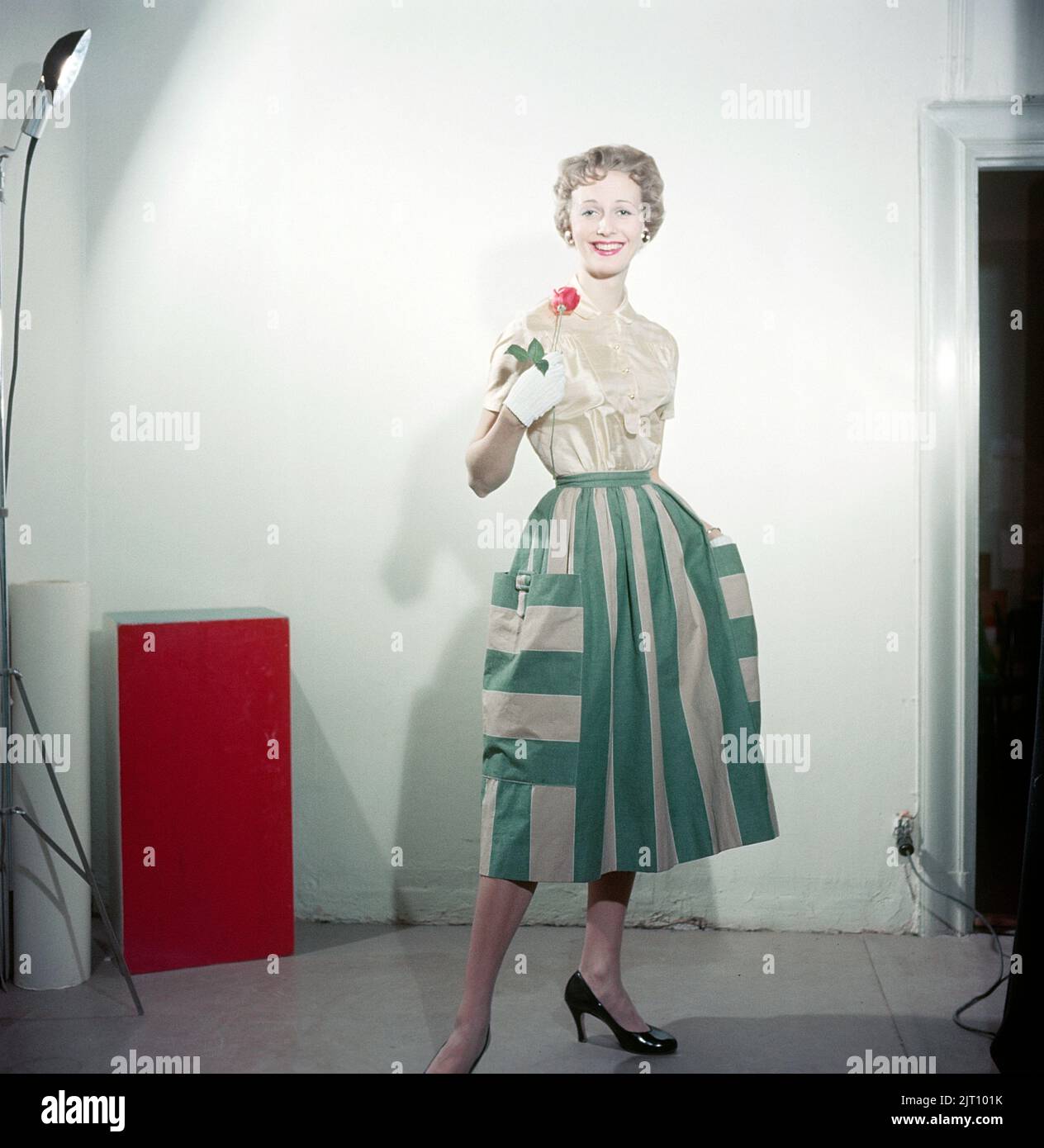1950s Mode. Eine junge Frau in einem typischen Kleid aus dem Jahr 1950s. Ein breiter Rock mit einem 50s-poligen Stoff. Schweden 1958 Conard Ref. BV105-9 Stockfoto