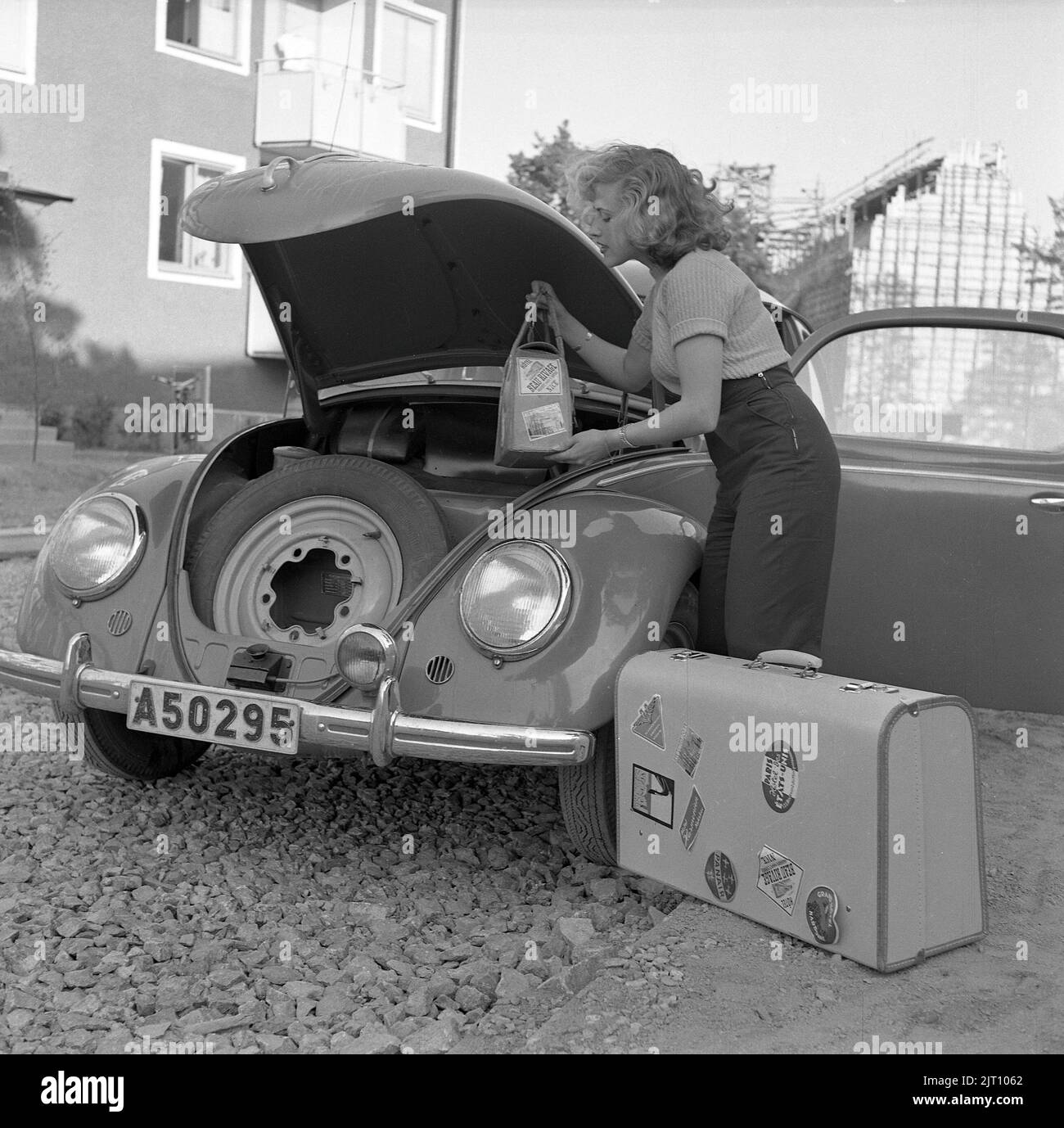Fahren im 1950s. Sängerin Bibi Johns geht auf Roadtrip und packt ihr Gepäck im Kofferraum ihres VW-Autos. Beachten Sie, dass das Auto seinen Motor im hinteren Teil des Autos und den Platz für Gepäck und Reserverad in der Front hat. Schweden 1951 Conard 1724 Stockfoto