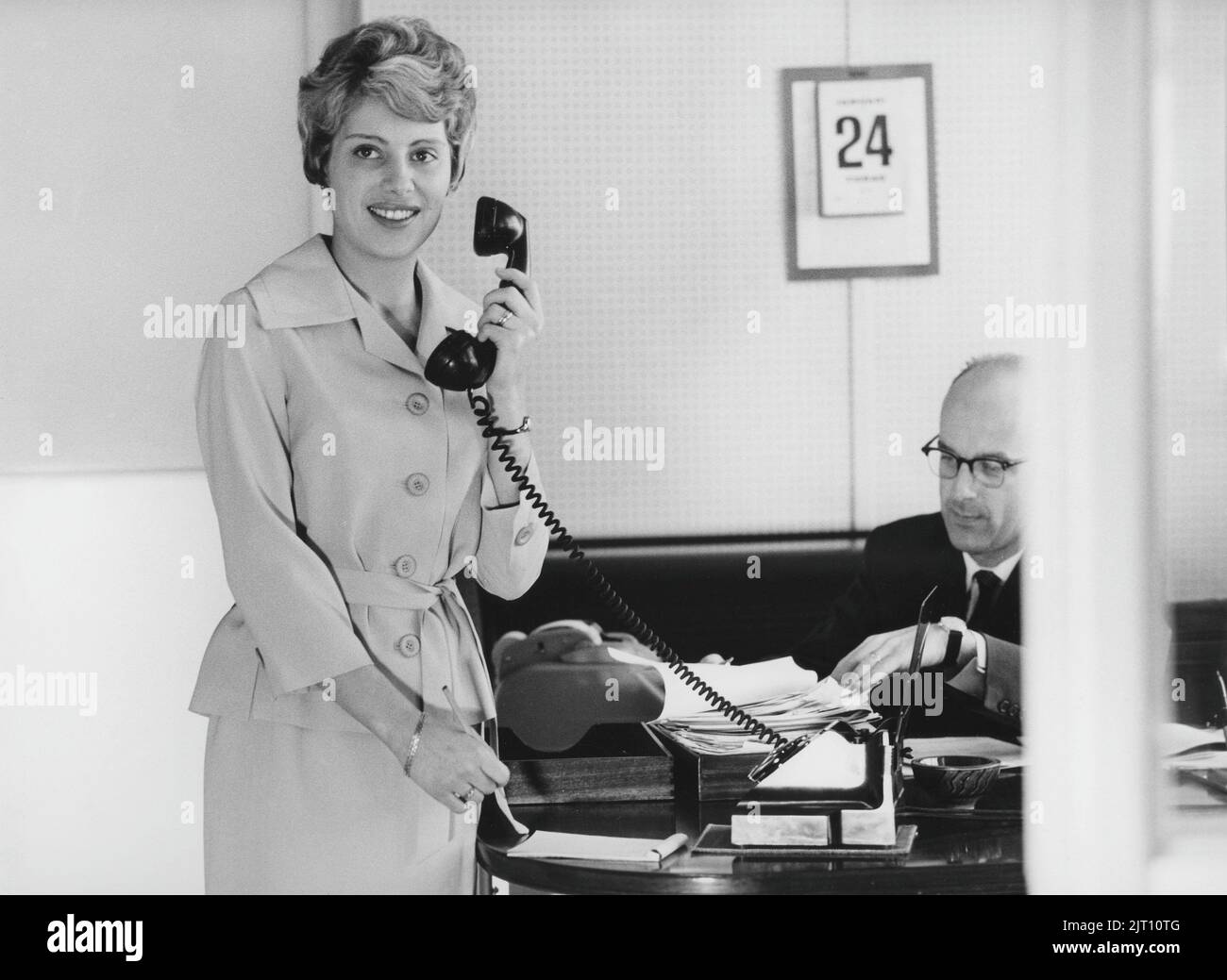 b-rom-dchen-in-den-1960s-eine-frau-steht-in-einem-b-ro-mit-einem-stift