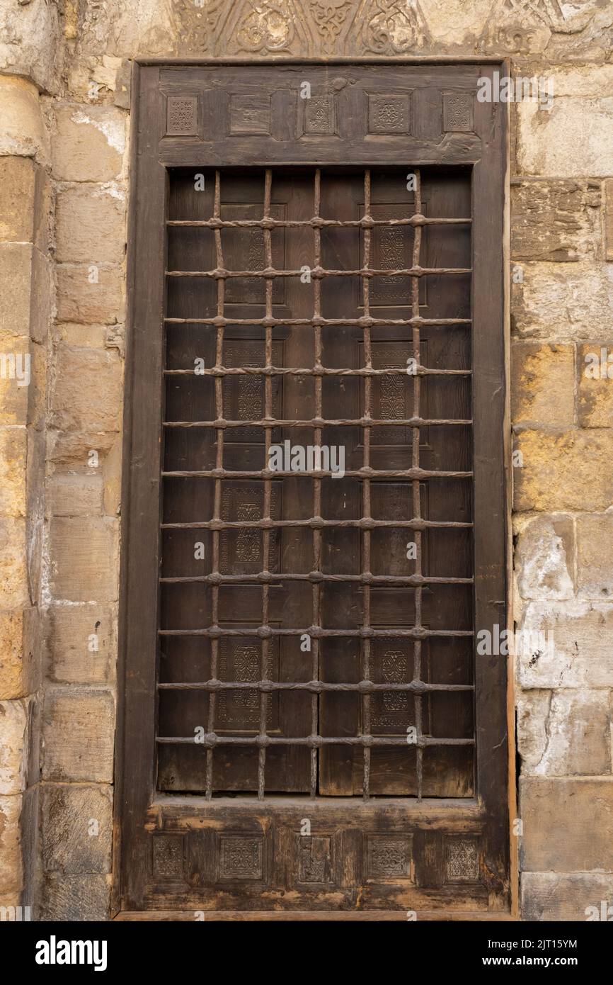 Beschädigte alte Steinwand mit Holzrahmen und Stahlstangen Fenster Stockfoto