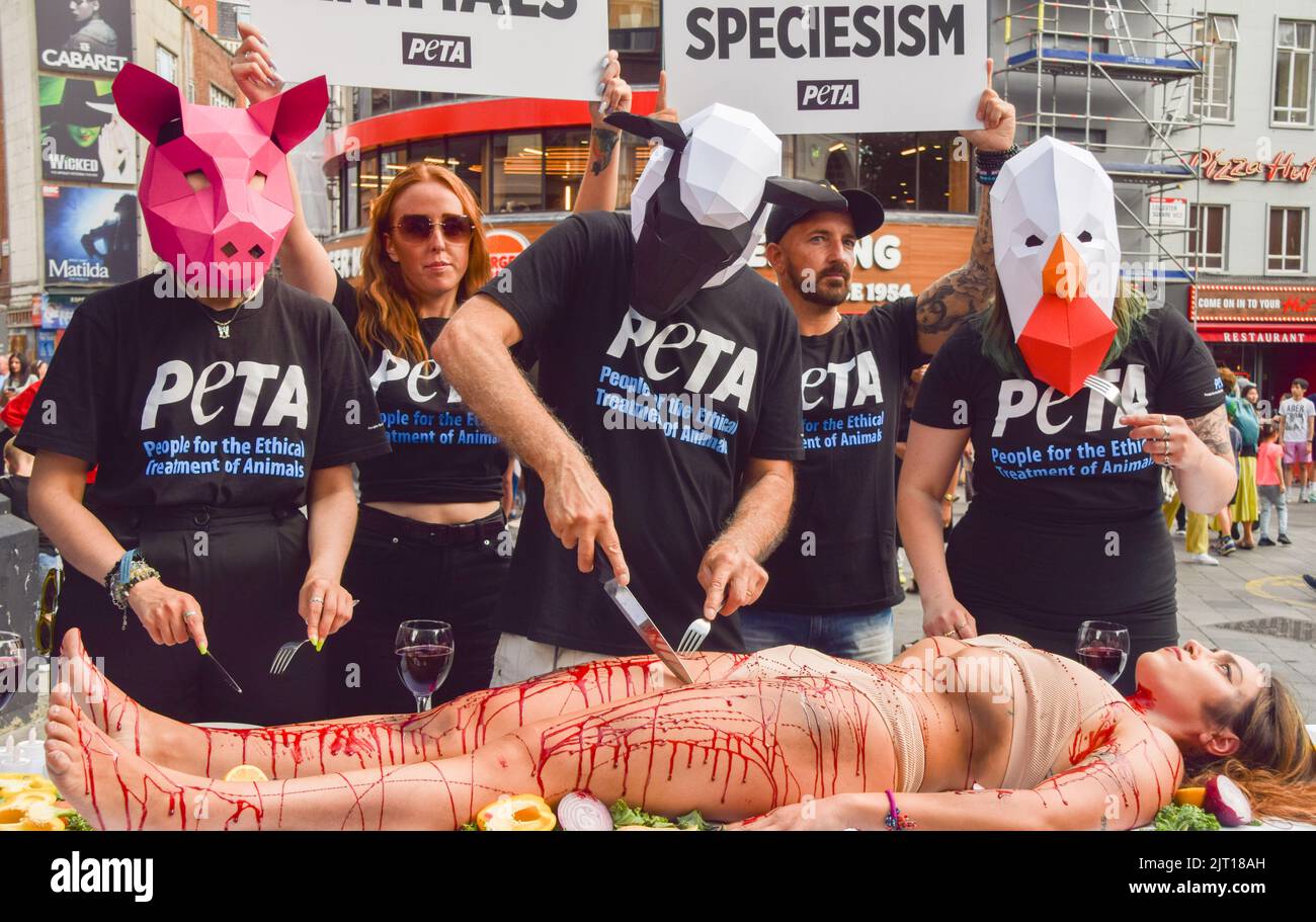 London, Großbritannien. 27.. August 2022. PETA-Aktivisten, die Tiermasken tragen, „gehen“ auf einem Menschen, der mit gefälschtem Blut bedeckt ist, auf dem Leicester Square. Die Aktion, die den Welttag für das Ende des Speziesismus markiert, ist Teil der laufenden Kampagne von PETA zur Beendigung des Speziesismus und zur Ermutigung der Menschen, vegan zu gehen. Kredit: Vuk Valcic/Alamy Live Nachrichten Stockfoto