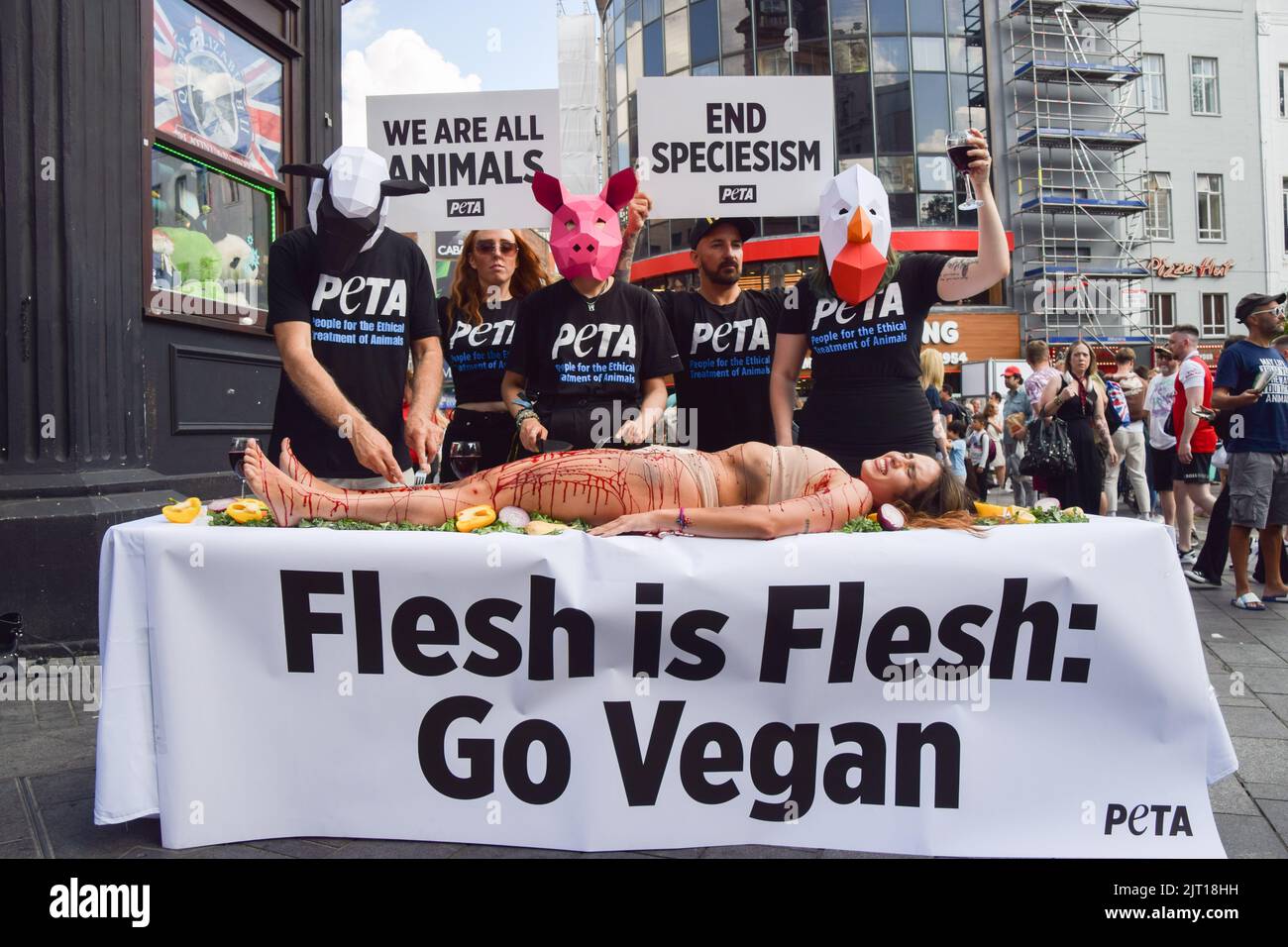 London, Großbritannien. 27.. August 2022. PETA-Aktivisten, die Tiermasken tragen, „gehen“ auf einem Menschen, der mit gefälschtem Blut bedeckt ist, auf dem Leicester Square. Die Aktion, die den Welttag für das Ende des Speziesismus markiert, ist Teil der laufenden Kampagne von PETA zur Beendigung des Speziesismus und zur Ermutigung der Menschen, vegan zu gehen. Kredit: Vuk Valcic/Alamy Live Nachrichten Stockfoto