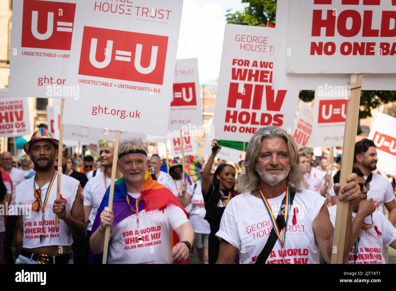 Manchester, Großbritannien. 27. August 2022. Mitglieder des George House Trust marschieren während der Pride Parade, um das Bewusstsein für HIV zu schärfen. In diesem Jahr wird die Parade zum ersten Mal seit 2019 wieder voll ausgelastet. Kredit: Andy Barton/Alamy Live Nachrichten Stockfoto