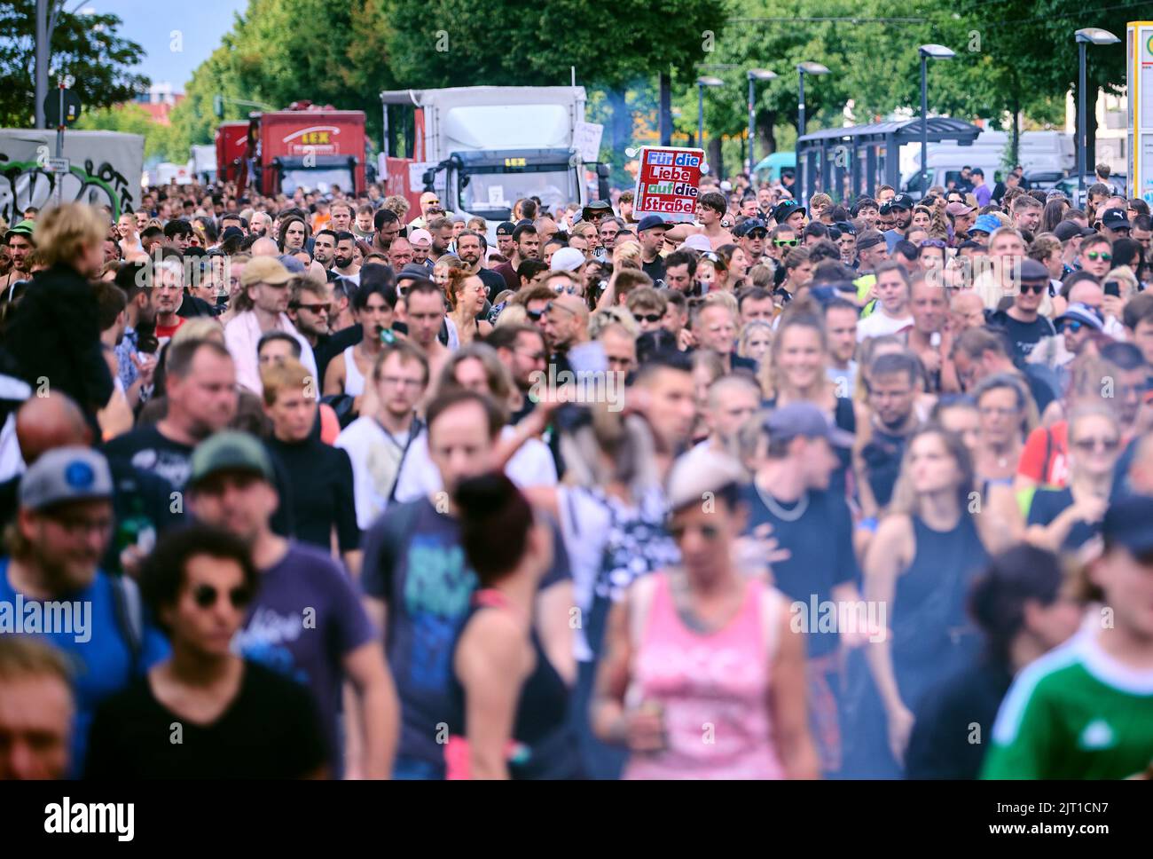 Berlin, Deutschland. 27. August 2022. "Für die Liebe auf der Straße" steht auf einem Schild in der tanzenden Menge. Die Techno-Parade 'Zug der Liebe' soll als Demonstration für mehr soziales Engagement dienen. Unter dem Motto 'sichtbar machen' wollen die Organisatoren auf zahlreiche karitative Initiativen aufmerksam machen. Quelle: Annette Riedl/dpa/Alamy Live News Stockfoto