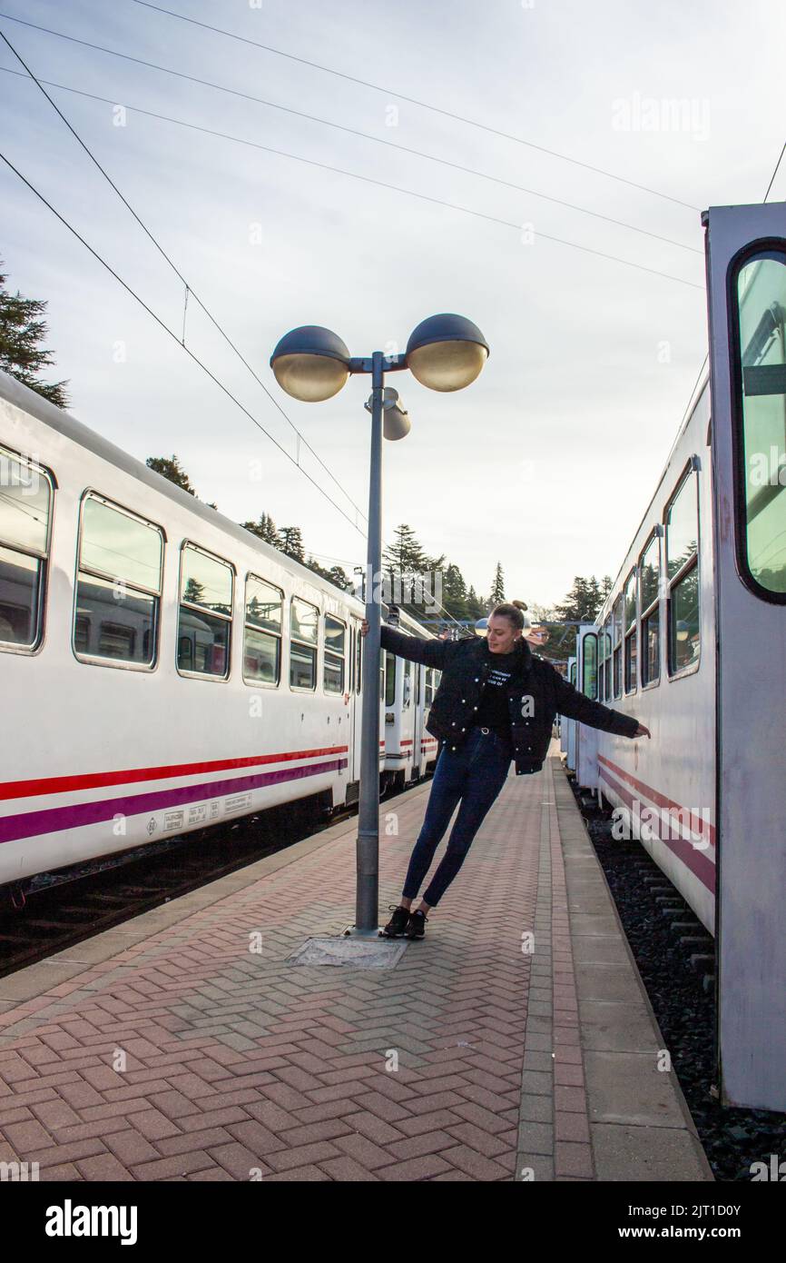 mujer rubia jugando en una estacion de tren espanola Stockfoto