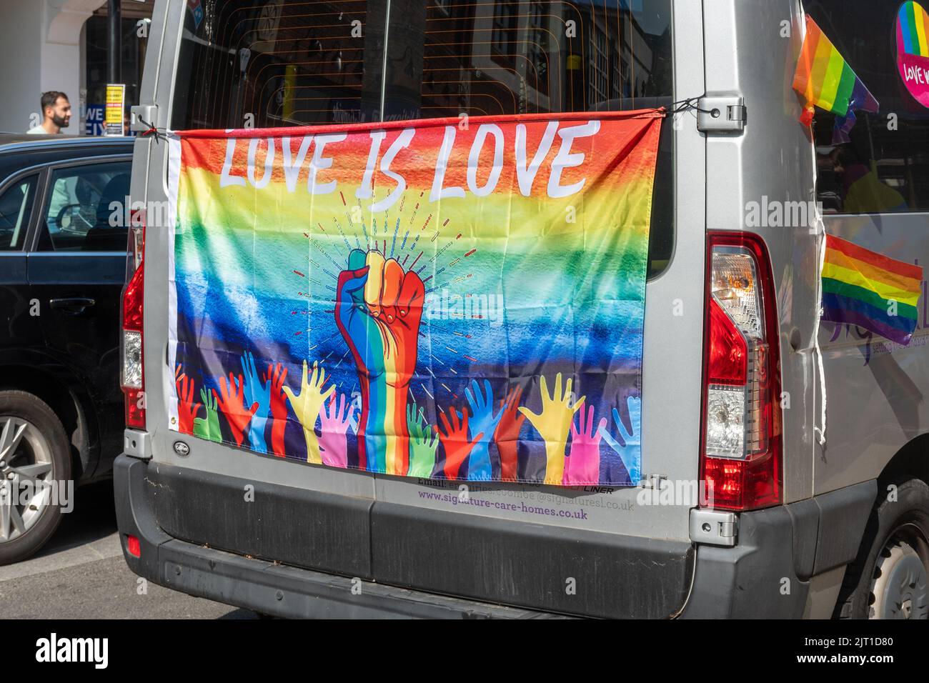 Pride in Surrey Parade in Camberley Town am 27.. August 2022, Surrey, England, Großbritannien. Die Liebe ist die Liebesflagge, die auf der Rückseite des Wagens angezeigt wird. Stockfoto