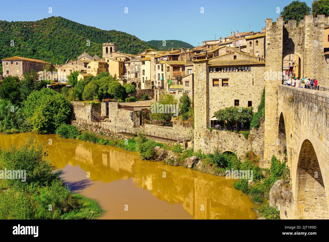 Alte Steinhäuser am Fluss und Reflexion im Wasser, Besalu Gerona Spanien. Stockfoto