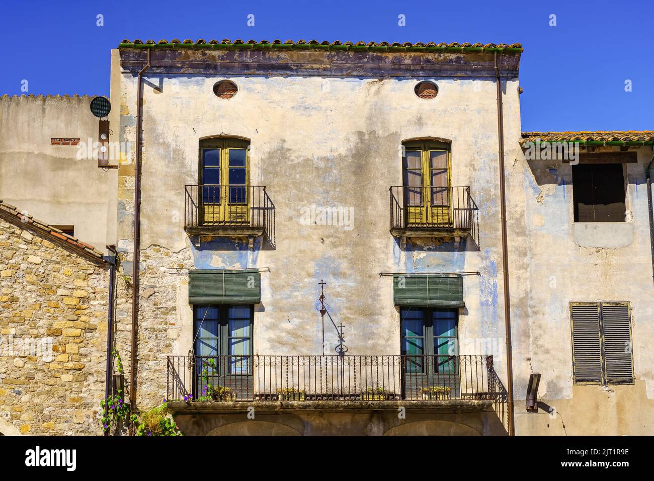 Malerische Fassade aus alten Häusern mit gegrillten Balkonen in der mittelalterlichen Stadt Besalu, Girona. Stockfoto