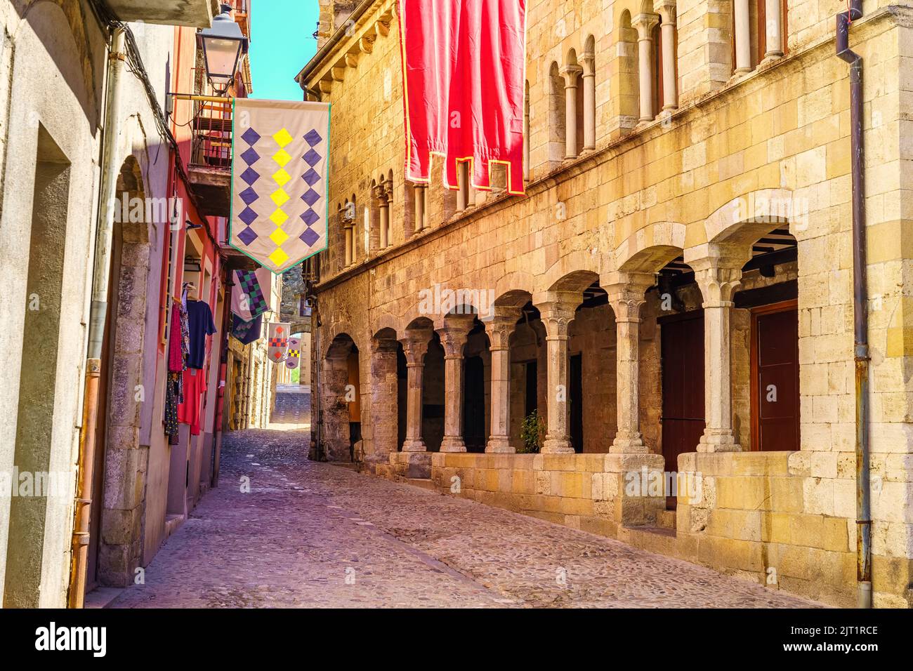 Schmale Gasse mit Steinhäusern und Säulenarkaden in der mittelalterlichen Stadt Besalu, Girona, Spanien. Stockfoto