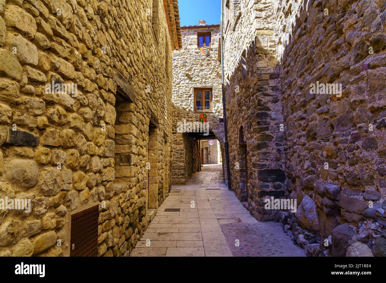 Malerische schmale Gasse mit vollständig aus Stein gebauten Häusern in der mittelalterlichen Stadt Besalu, Girona. Stockfoto