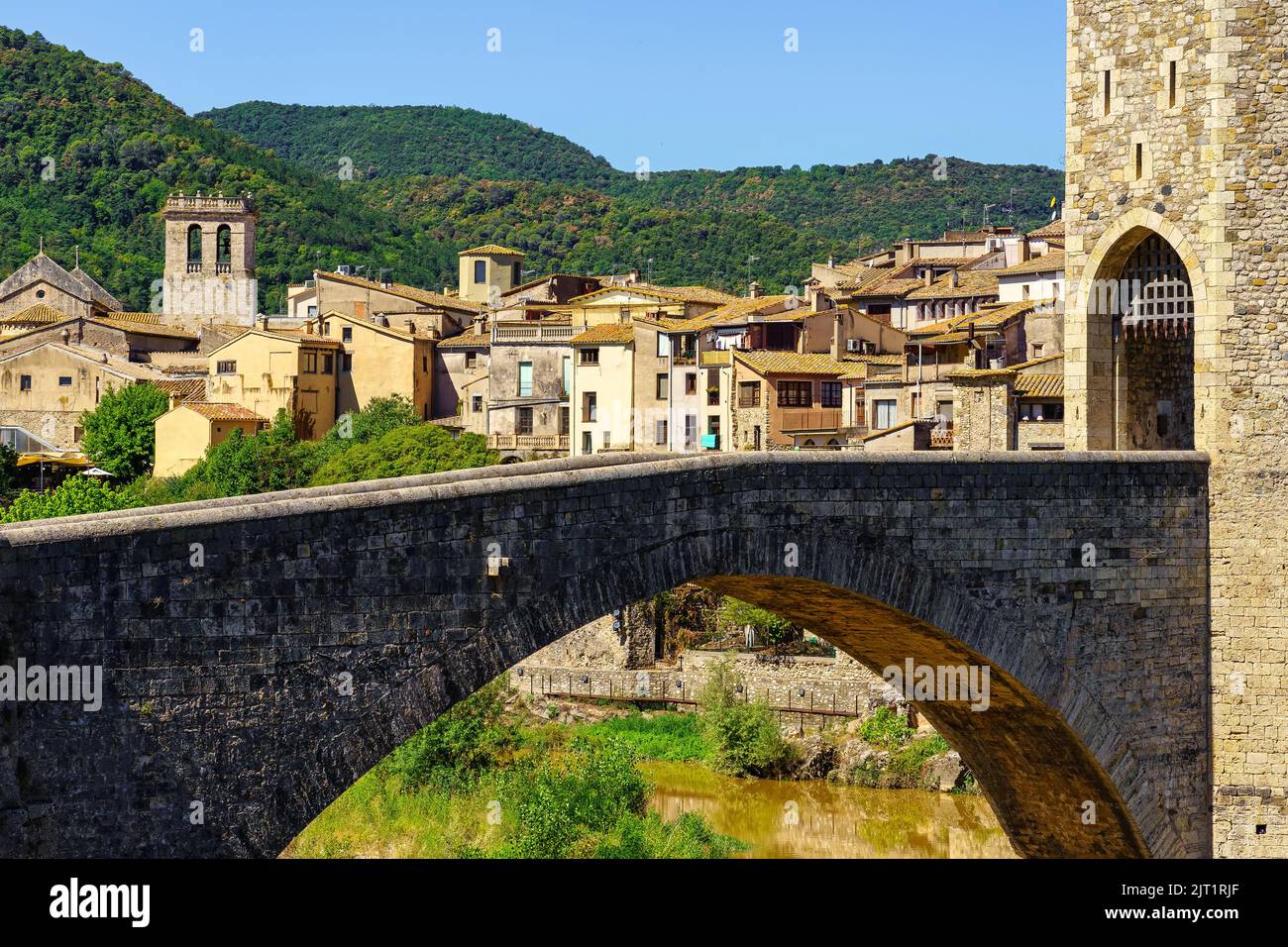 Alte Steinbrücke und mittelalterliche Häuser im Hintergrund in der Touristenstadt Besalu, Girona, Spanien. Stockfoto