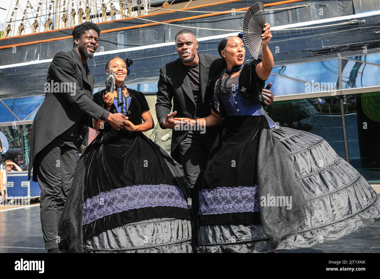 London, Großbritannien, 27.. August 2022. Black Victorians wird vor der wunderschönen Kulisse der Cutty Sark Gardens beim Greenwich and Docklands International Festival aufgeführt. Diese kraftvolle Tanzperformance des künstlerischen Leiters und Choreographen Jeanefer Jean-Charles MBE ist inspiriert von Studiofotografien schwarzer Männer, Frauen und Kinder aus dem 19. Jahrhundert. In dem Stück geht es darum, durch Bewegung, Text und Musik Stimme und Körper zu den Figuren in den Porträts zu bringen. Das Publikum erlebt fünf vielseitige Tänzer, die sich die Geschichten der viktorianischen Figuren durch eine Reihe von Tanzstilen neu vorstellen. Stockfoto