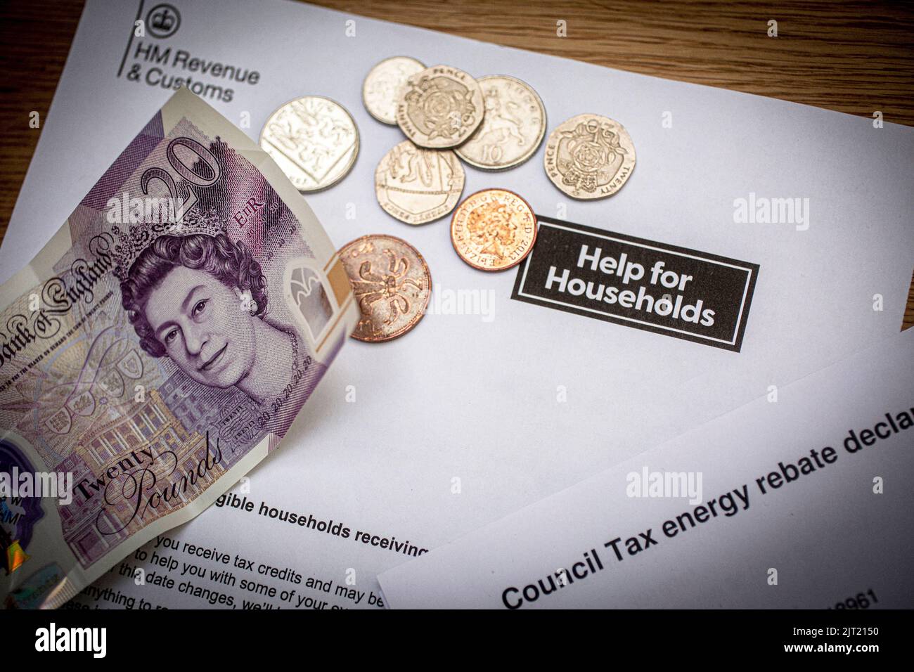 Britische £20-Note und Münzen auf dem Schreiben der Regierung von HM, in dem die britische Regierung über Haushaltshilfe informiert wurde, Vereinigtes Königreich Stockfoto