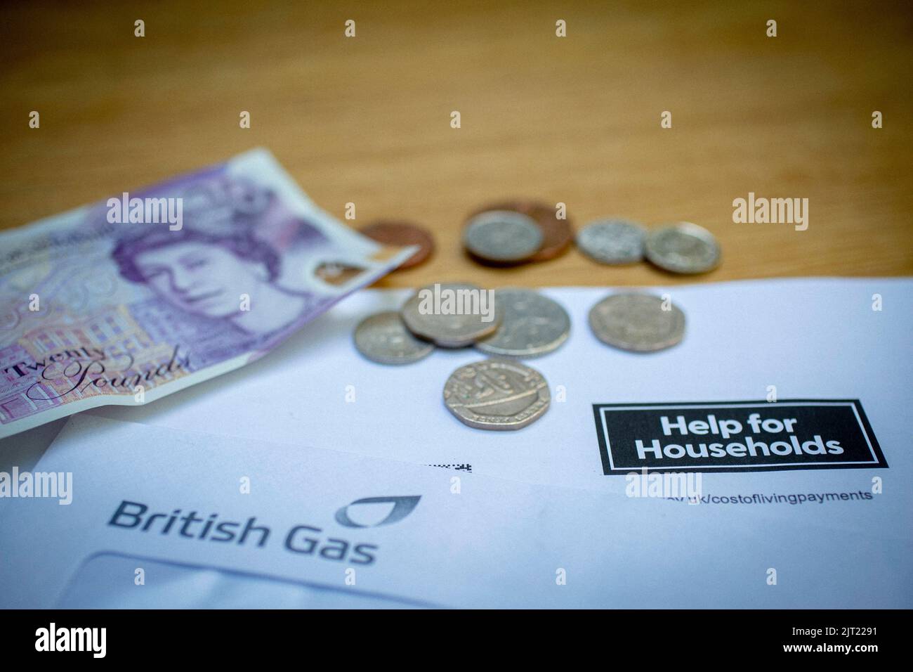 Britische £20-Note und Münzen auf Regierungsschreiben der britischen Regierung, in dem die Haushaltshilfe der britischen Regierung, England, Vereinigtes Königreich, gemeldet wurde Stockfoto