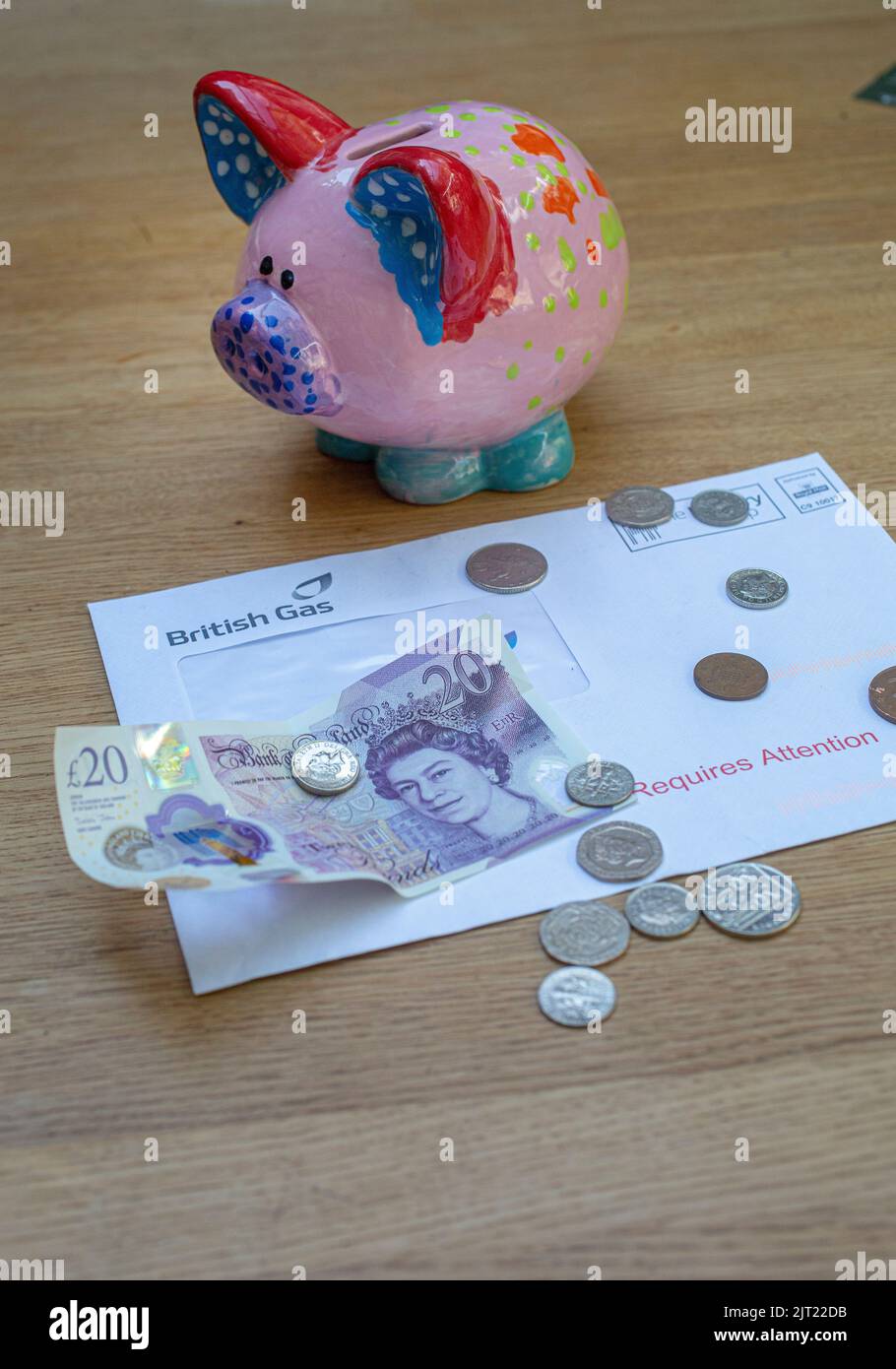 Sparschwein mit Gasrechnung, britischer £20-Note und Münzen als Treibstoffrechnung Rakete Stockfoto