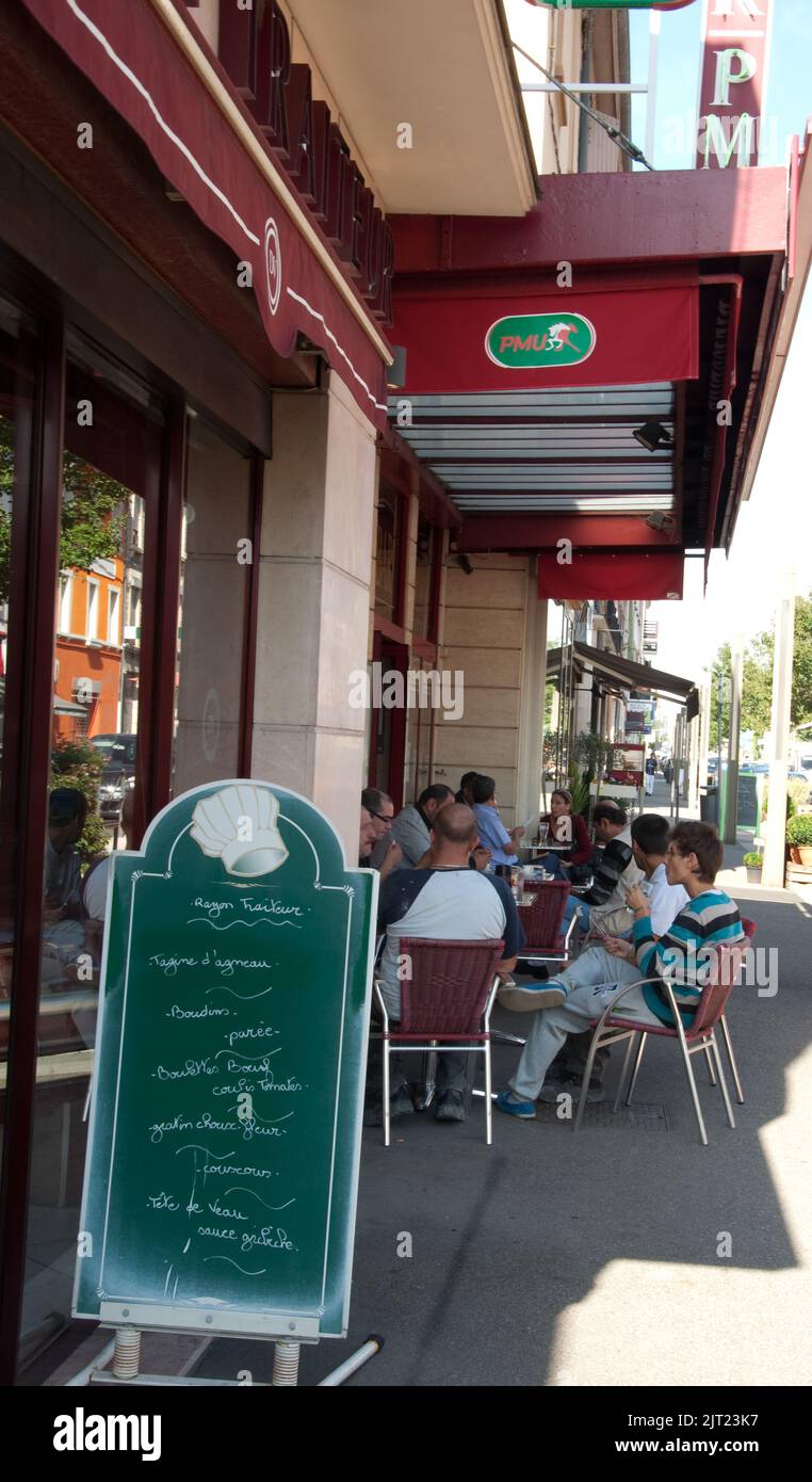 Blick auf die Straße, Champagne au Mont d'Or, Rhone, Rhone Alpes, Frankreich. Menschen sitzen in einem Café, trinken und essen, plaudern. Stockfoto