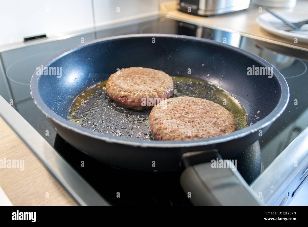 Zwei Burger Patties Burger Fleisch sizzling in heißer Pfanne mit Fett ...