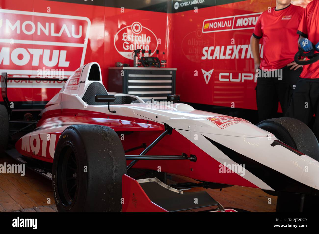 Ein roter Formel-1-Rennwagen in der Box mit Werkzeugen und Mechaniker-Team daneben Stockfoto