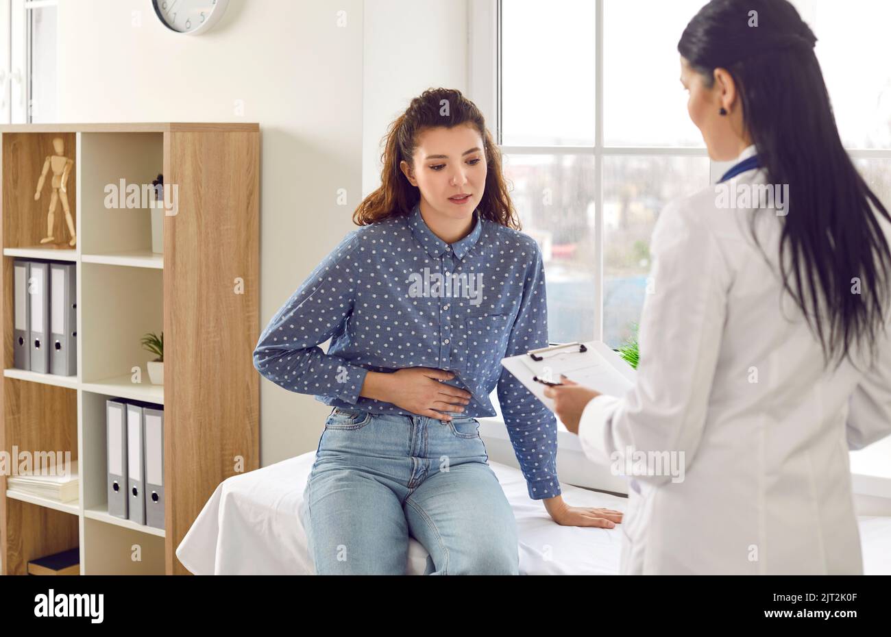 Eine Fachärztin berät junge Patientinnen, die sich über Bauchschmerzen beklagt. Stockfoto