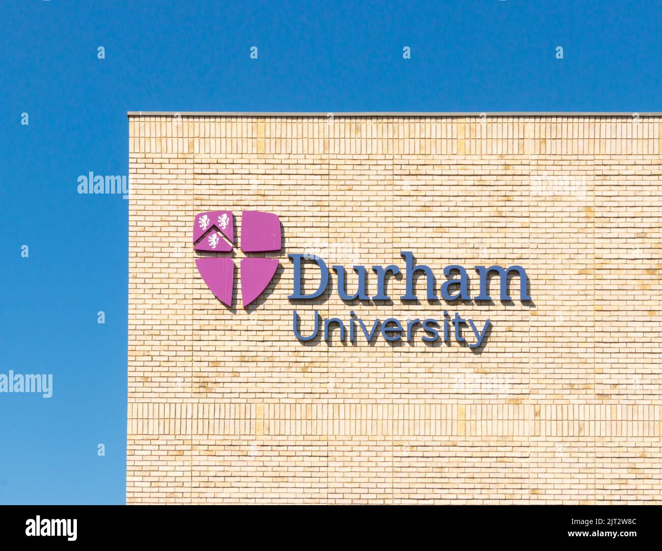 Schild oder Logo der Durham University auf dem Schild an der sonnenbeschienenen Ziegelwand. Grafschaft Durham, Großbritannien Stockfoto