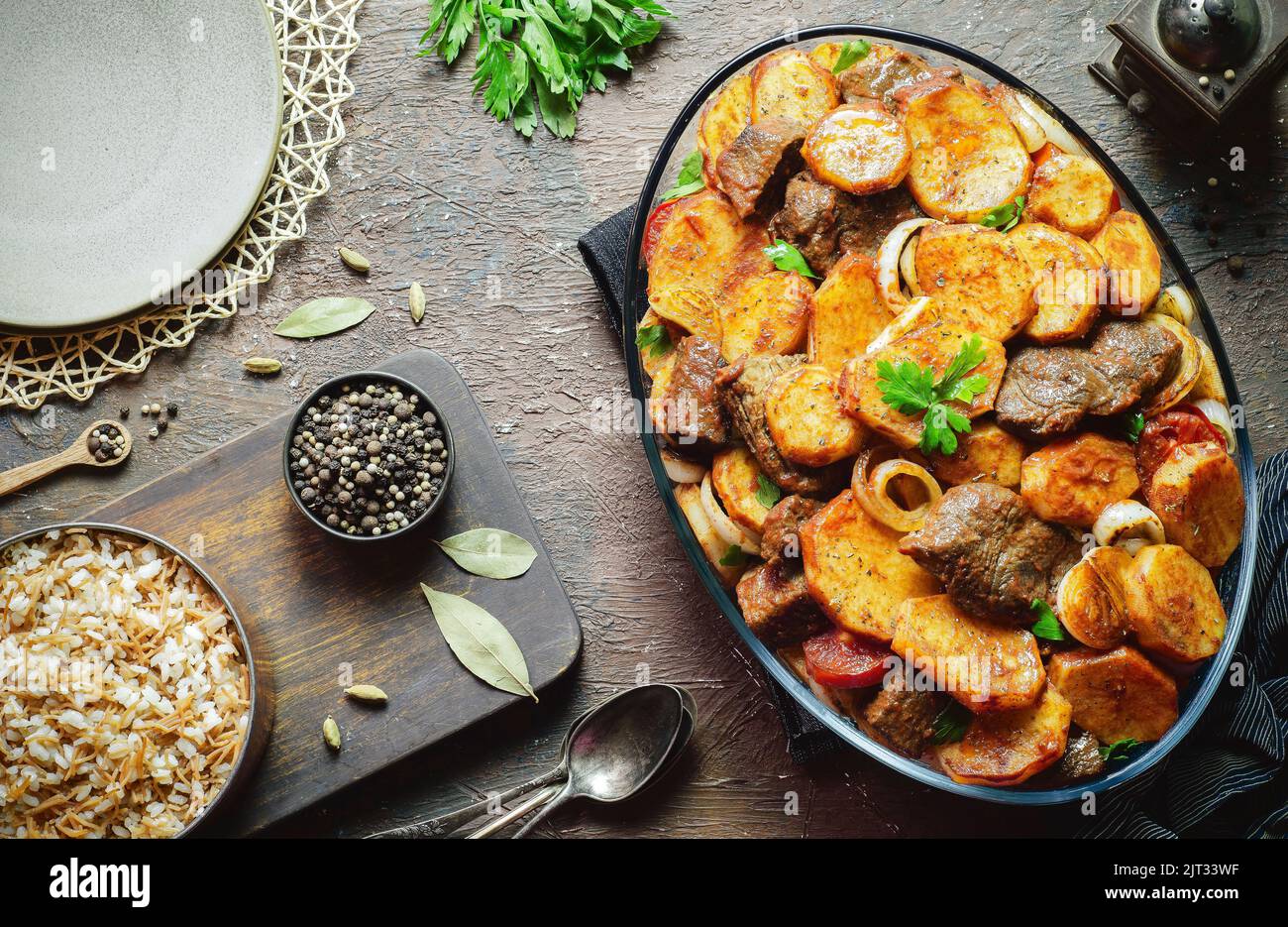 Arabische Küche; ägyptisch-orientalisches Gericht „gebackene Kartoffeln mit Kalbsstückchen“, serviert mit traditionellem Reis mit Vermicelli. Draufsicht mit Kopierbereich. Stockfoto