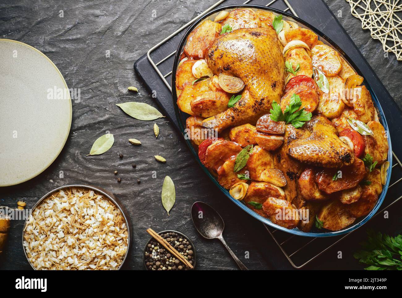 Arabische Küche; ägyptisches traditionelles Gericht „gebackene Kartoffeln mit gebratenem Huhn“ serviert mit orientalischem Reis mit Vermicelli. Draufsicht mit Kopierbereich. Stockfoto