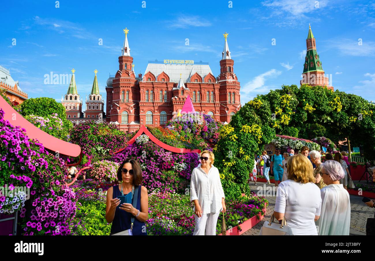 Moskau - 2. Aug 2022: Blumenfest auf dem Manezhnaya-Platz, Moskau, Russland. Historisches Museum und Kreml, Sehenswürdigkeiten in der Ferne. Menschen Stockfoto