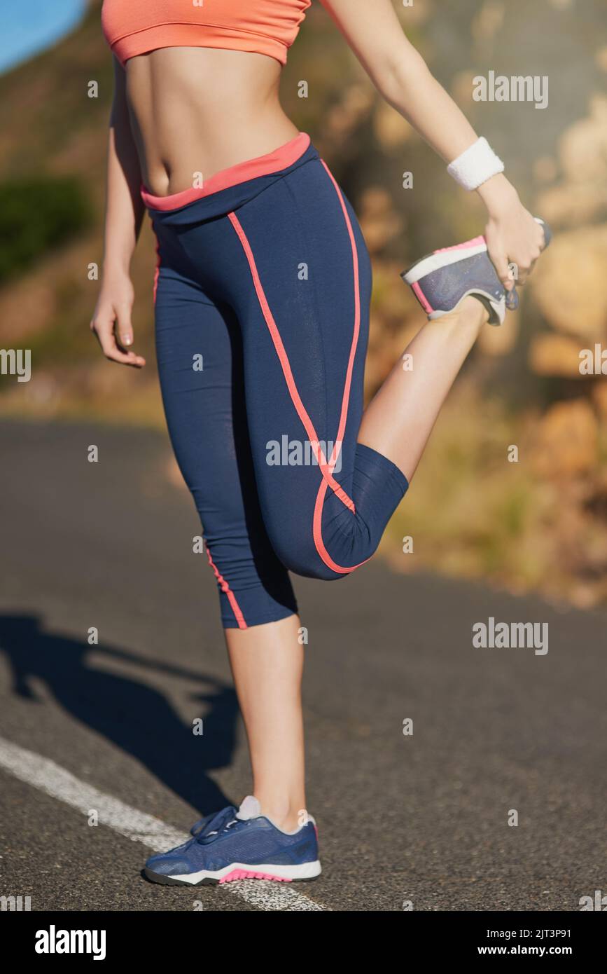 Eine nicht erkennbare junge Frau, die sich vor einem Training aufwärmt. Stockfoto