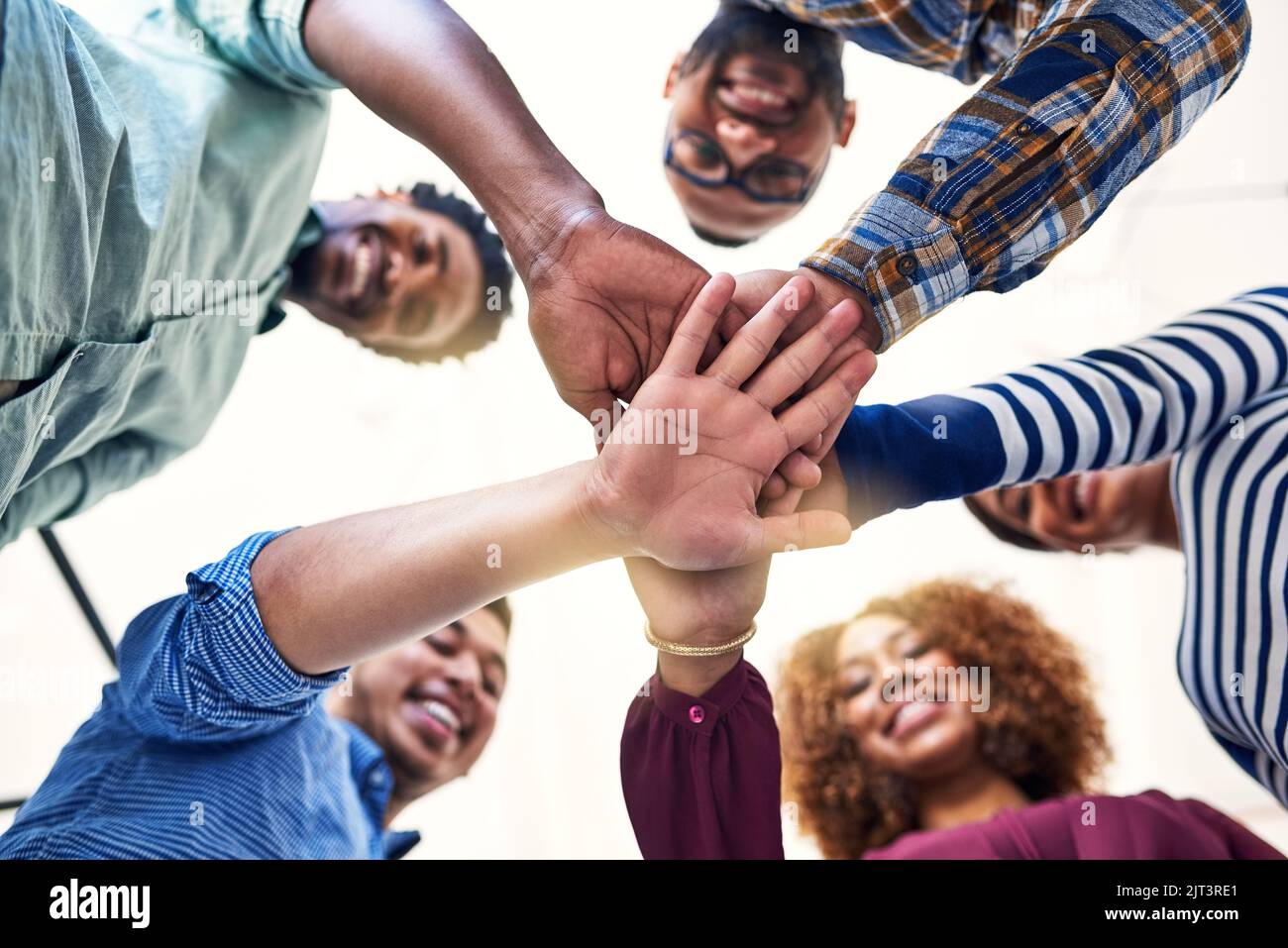 Es ist wichtig, Stärke und Vertrauen als Team aufzubauen. Low-Angle-Aufnahme eines Teams von Designern, die ihre Hände in Einheit zusammenfügen. Stockfoto