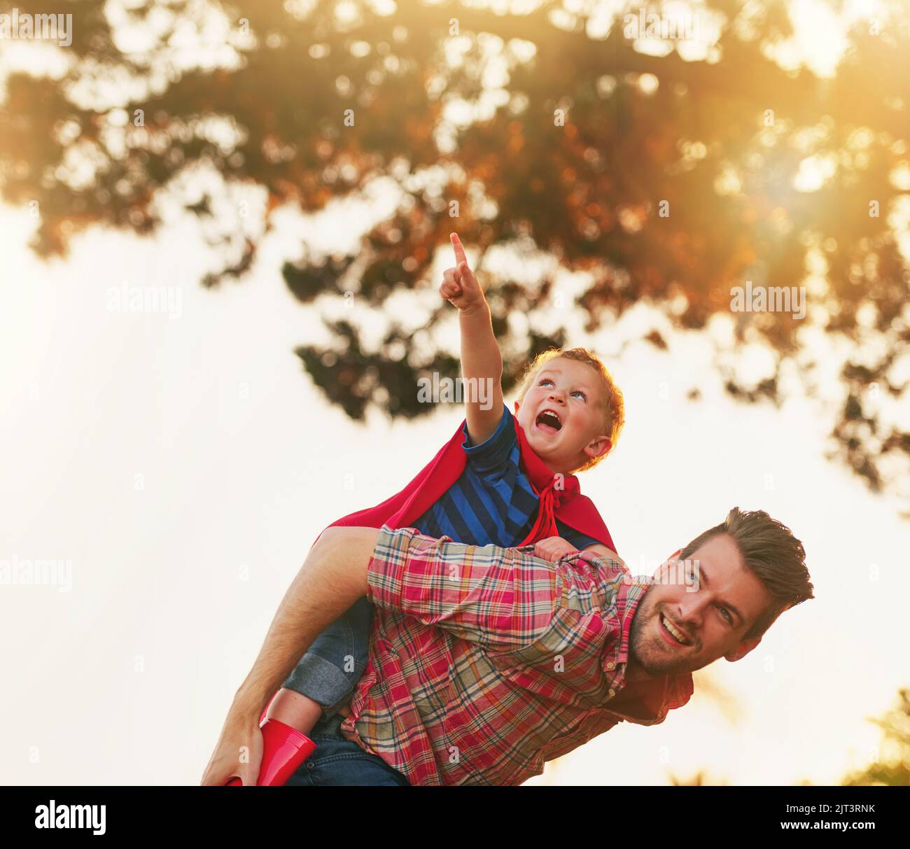 Lasst uns zu dieser Wolke fliegen, Papa. Ein süßer kleiner Junge und sein Vater, der spielt, lassen es draußen glauben. Stockfoto