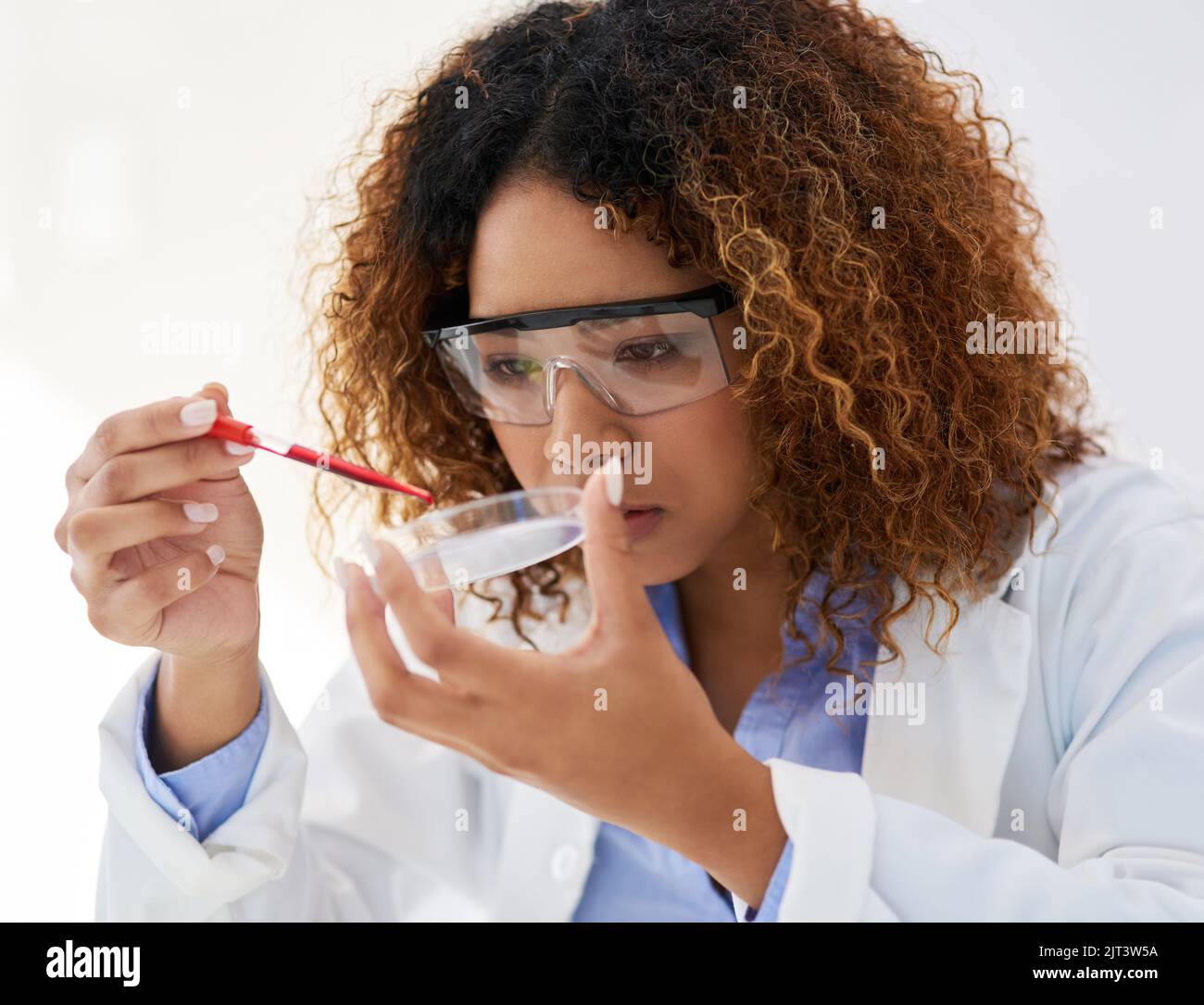 Sie braucht nur einen einzigen Tropfen. Eine junge Wissenschaftlerin, die eine Probe im Labor analysiert. Stockfoto