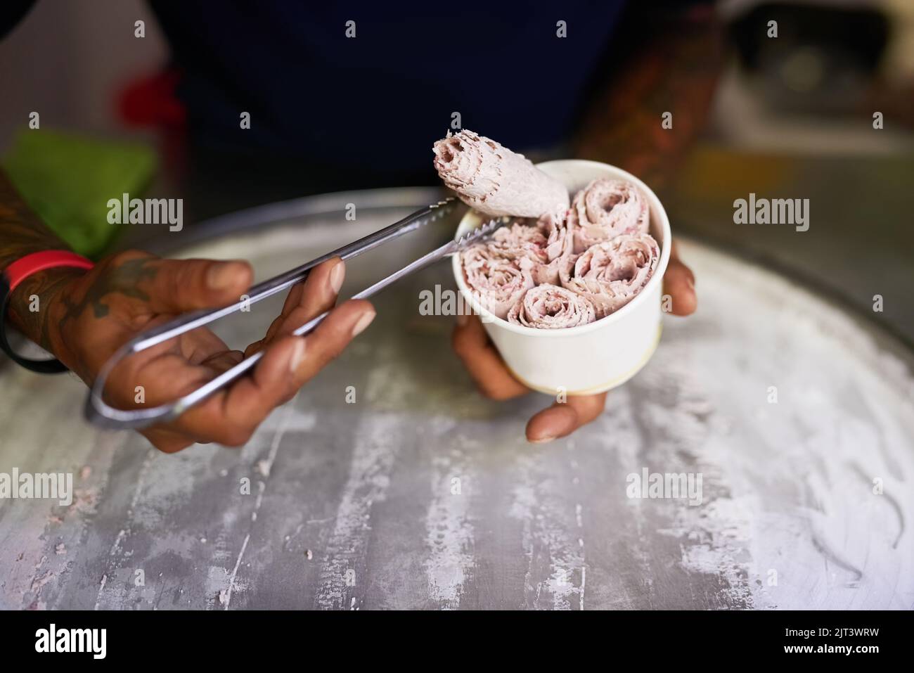 Ihre Geschmacksknospen werden Danke., einen nicht identifizierbaren Lebensmittelhändler, der an einem Marktstand ein süßes Leckerbissen vorbereitet. Stockfoto
