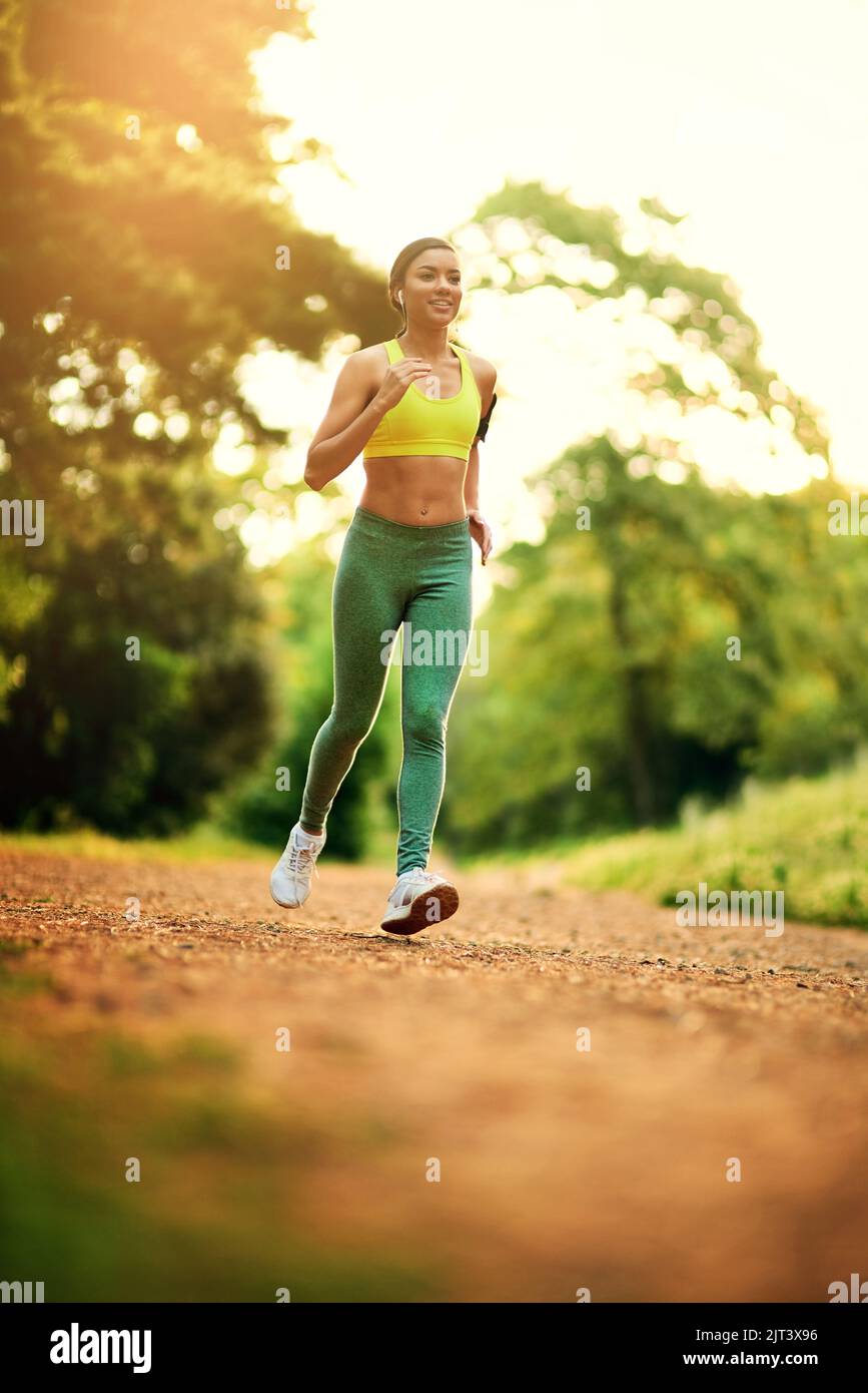 Es gibt immer einen Grund zu laufen. Eine junge Frau, die in einer natürlichen Umgebung läuft. Stockfoto