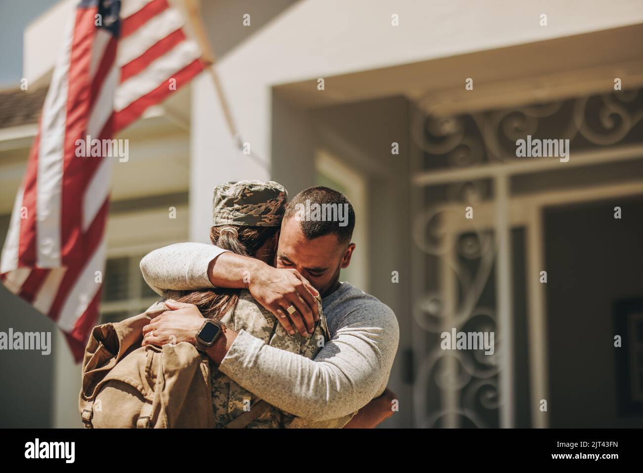 Emotionale militärische Heimkehr. Eine Soldatin umarmte ihren Mann, nachdem sie von der Armee nach Hause zurückgekehrt war. Die amerikanische Militärangehörerin vereinigt sich wieder mit ihrer Husba Stockfoto