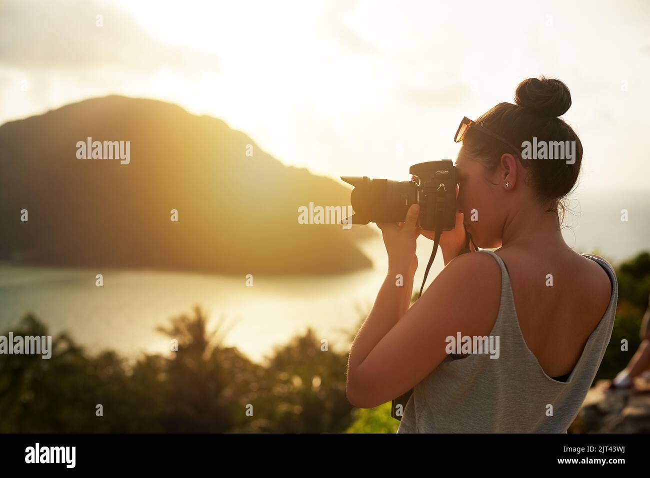 Die ganze Schönheit der Natur einfangen. Eine junge Frau fotografiert im Urlaub einen tropischen Ausblick. Stockfoto