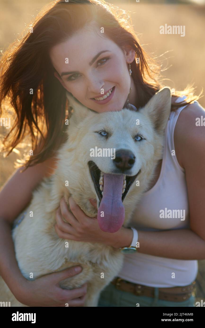 Mit viel Liebe und Aufmerksamkeit geduscht. Porträt einer attraktiven jungen Frau, die sich im Freien mit ihrem Hund verklebt. Stockfoto