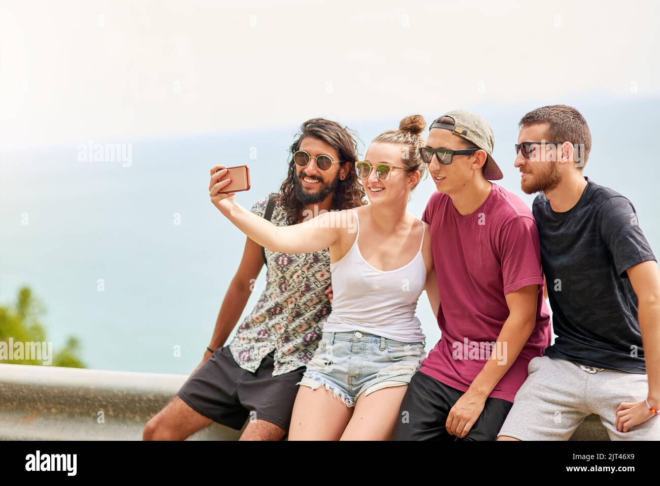 Freunde machen alles mehr Spaß. Eine Gruppe von Freunden posiert für ein Selfie, während sie sich draußen entspannen. Stockfoto