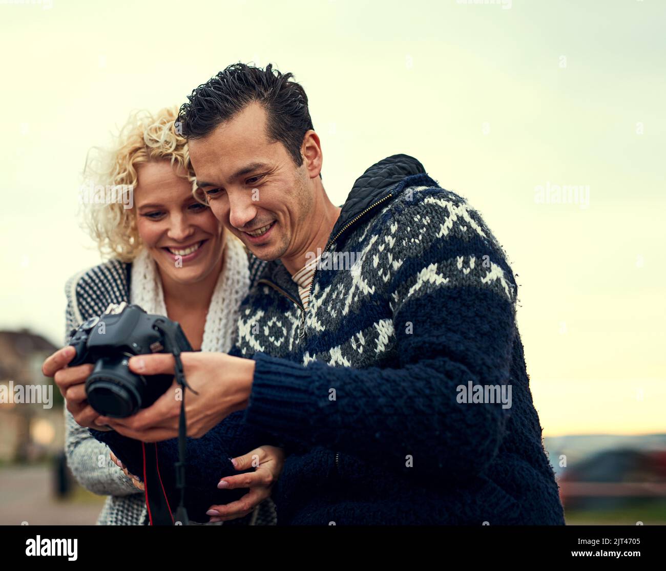 Sehen Sie sich dieses Foto an. Ein junges Paar, das sich im Urlaub Fotos ansieht. Stockfoto