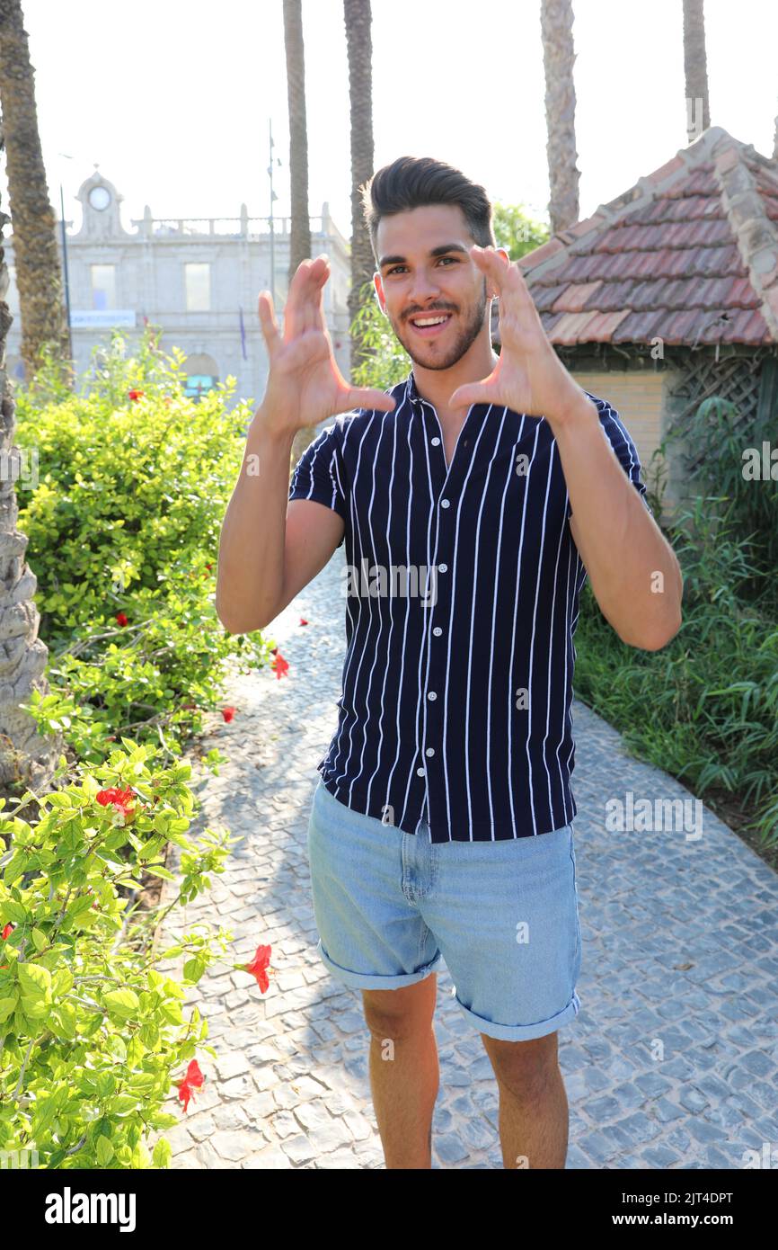 In seinem Garten posiert ein fröhlicher junger Bauer in lässiger Kleidung Stockfoto
