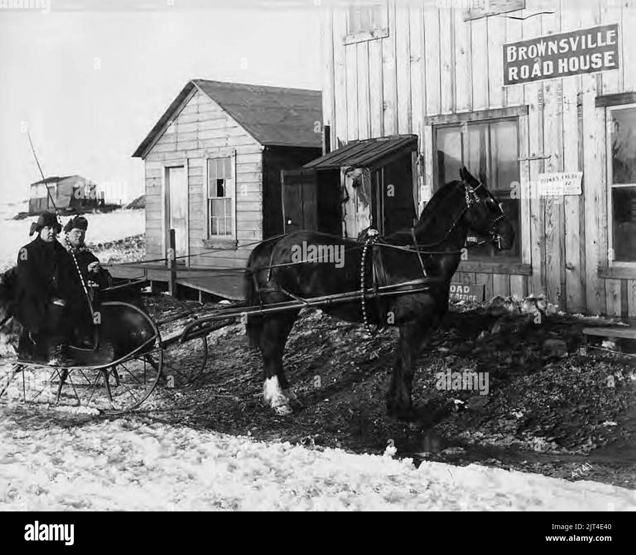 Zwei Männer im Pferdeschlitten vor dem Roadhouse, Nome, Alaska, um 1905 (AL CA 7506). Stockfoto