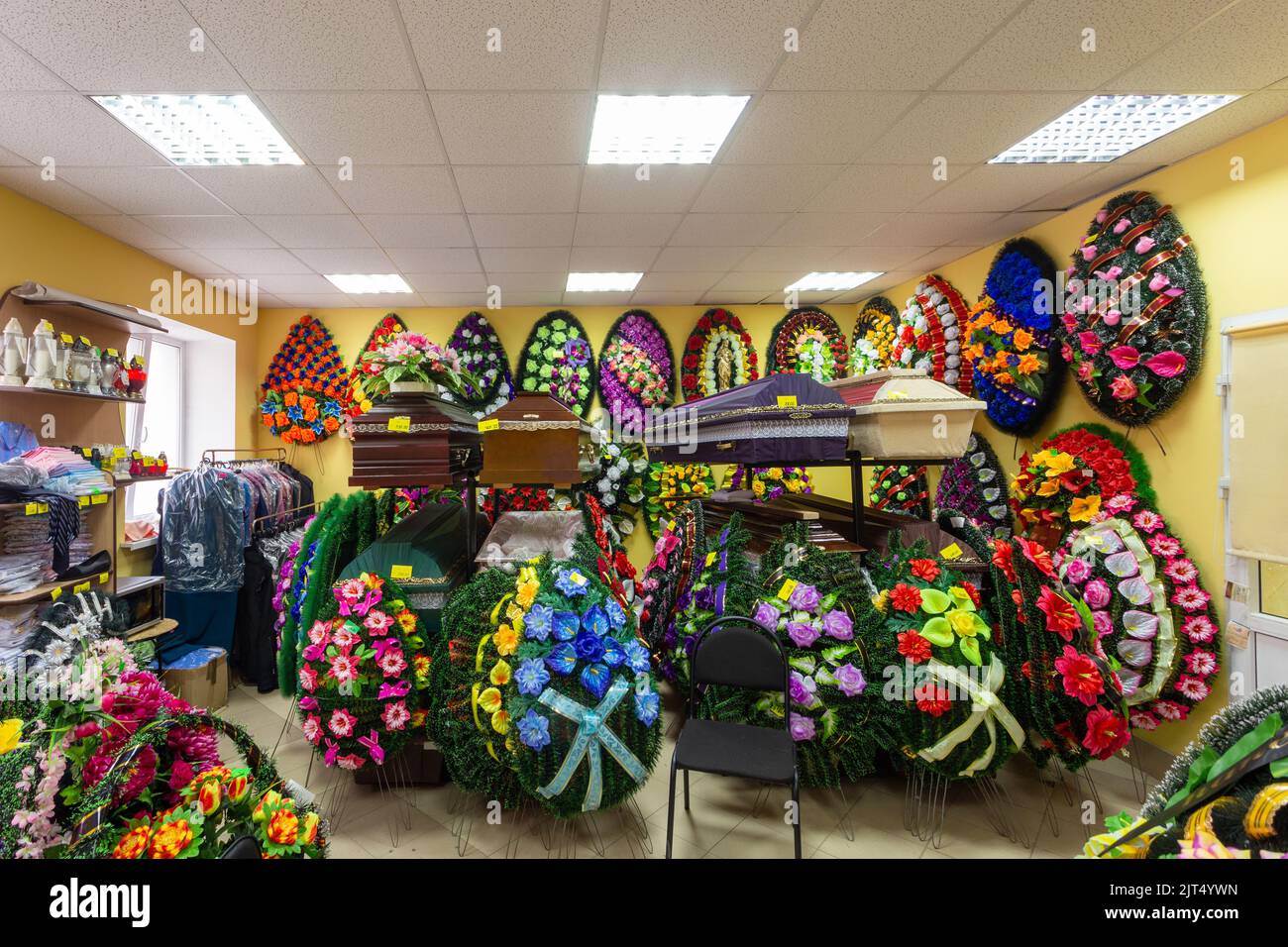 Innenraum des Raumes mit Bestattungszubehör. Geschäft mit Särgen, Beerdigungskränzen und Blumen. Stockfoto
