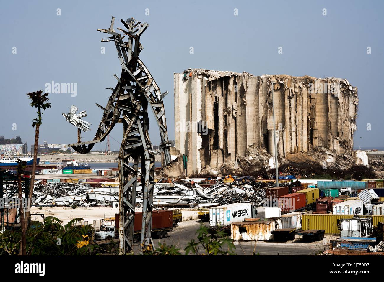 Beirut, Libanon: Vor den zerstörten Getreidesilos steht die Stahlskulptur des Künstlers Nadim Karam, die an die Opfer der tödlichen Explosion vom 4. August 2020 erinnert, die aus dem Schrott der massiven Explosion von 2.750 Tonnen Ammoniumnitrat im Hafen hergestellt wurde. Stockfoto