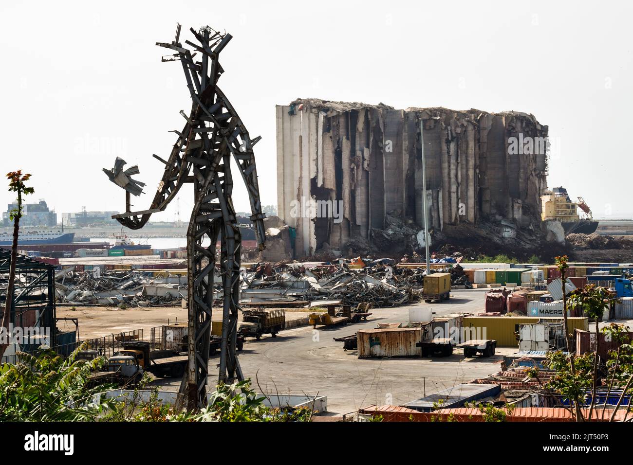 Beirut, Libanon: Vor den zerstörten Getreidesilos steht die Stahlskulptur des Künstlers Nadim Karam, die an die Opfer der tödlichen Explosion vom 4. August 2020 erinnert, die aus dem Schrott der massiven Explosion von 2.750 Tonnen Ammoniumnitrat im Hafen hergestellt wurde. Stockfoto