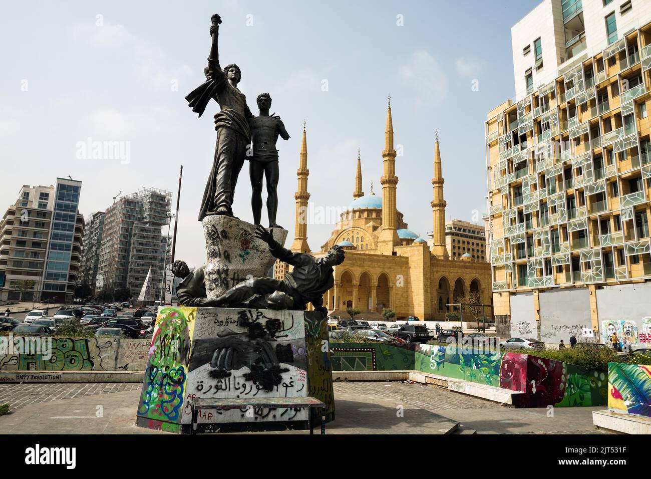 Beirut, Libanon: Denkmal zur Erinnerung an die Märtyrer, die von den Osmanen hingerichtet wurden, durchsetzt von Einschusslöchern aus dem libanesischen Bürgerkrieg, Martyrs' Square. Im Hintergrund die Mohammad Al-Amin sunnitisch muslimische Moschee, auch Blaue Moschee genannt, im Zentrum, Libanon Stockfoto