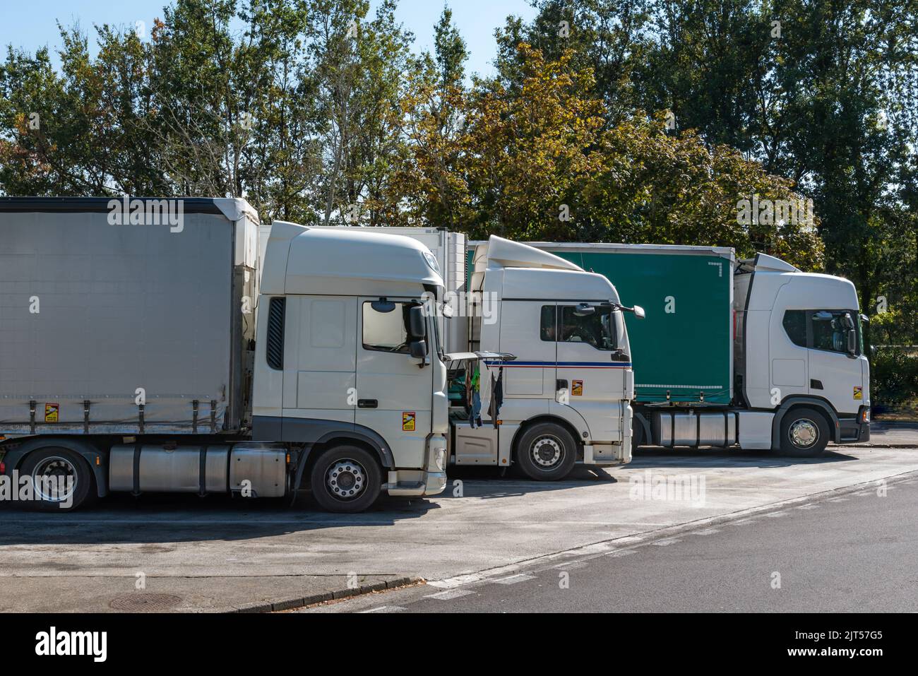 Mehrere LKWs machen auf einem Parkplatz eine Pause. Stockfoto