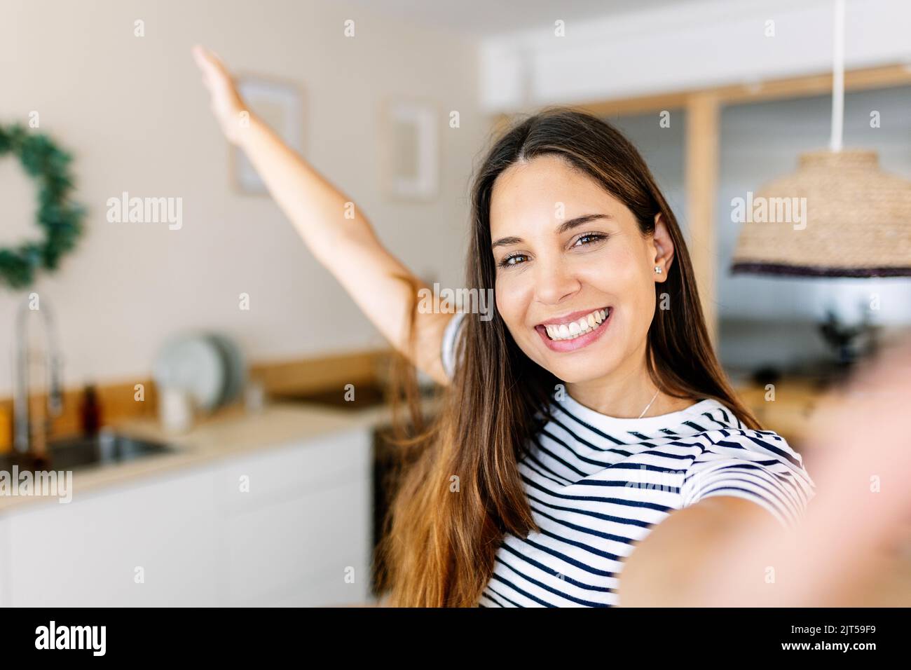 Heitere glückliche junge Erwachsene Frau, die zu Hause Selfie-Porträt mit dem Telefon macht Stockfoto